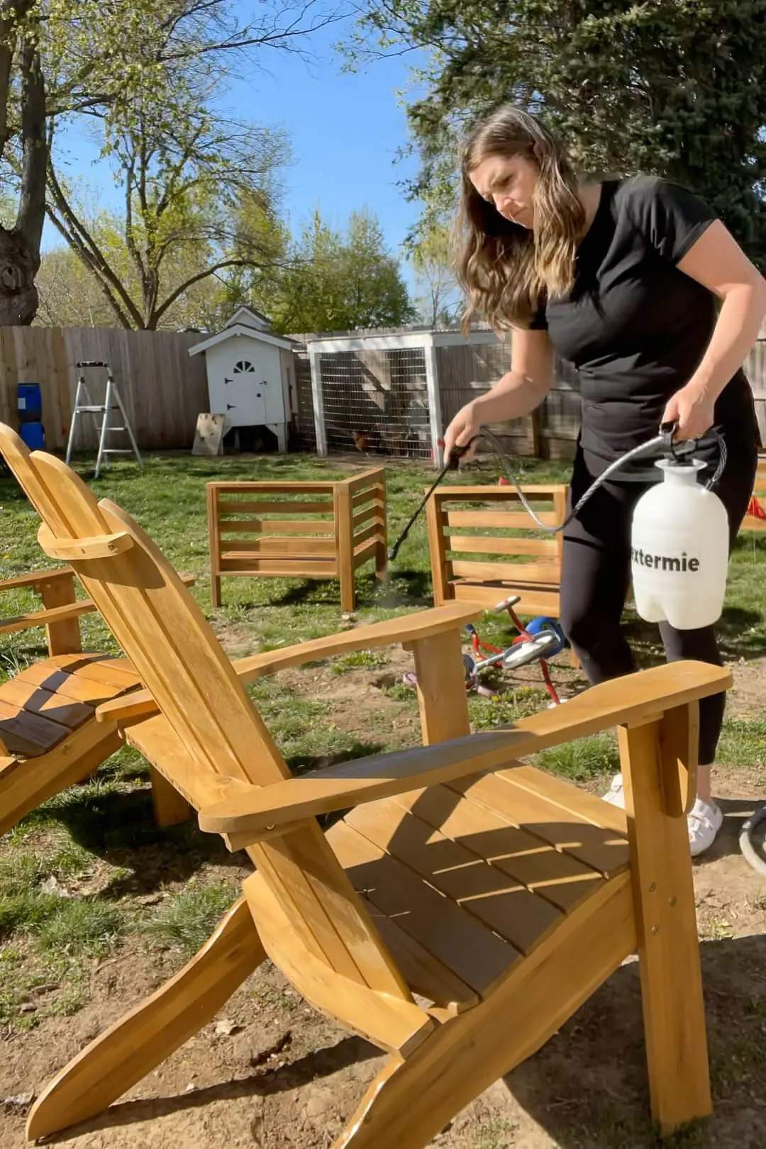 Using a sprayer to apply clear sealant to protect outdoor patio furniture.