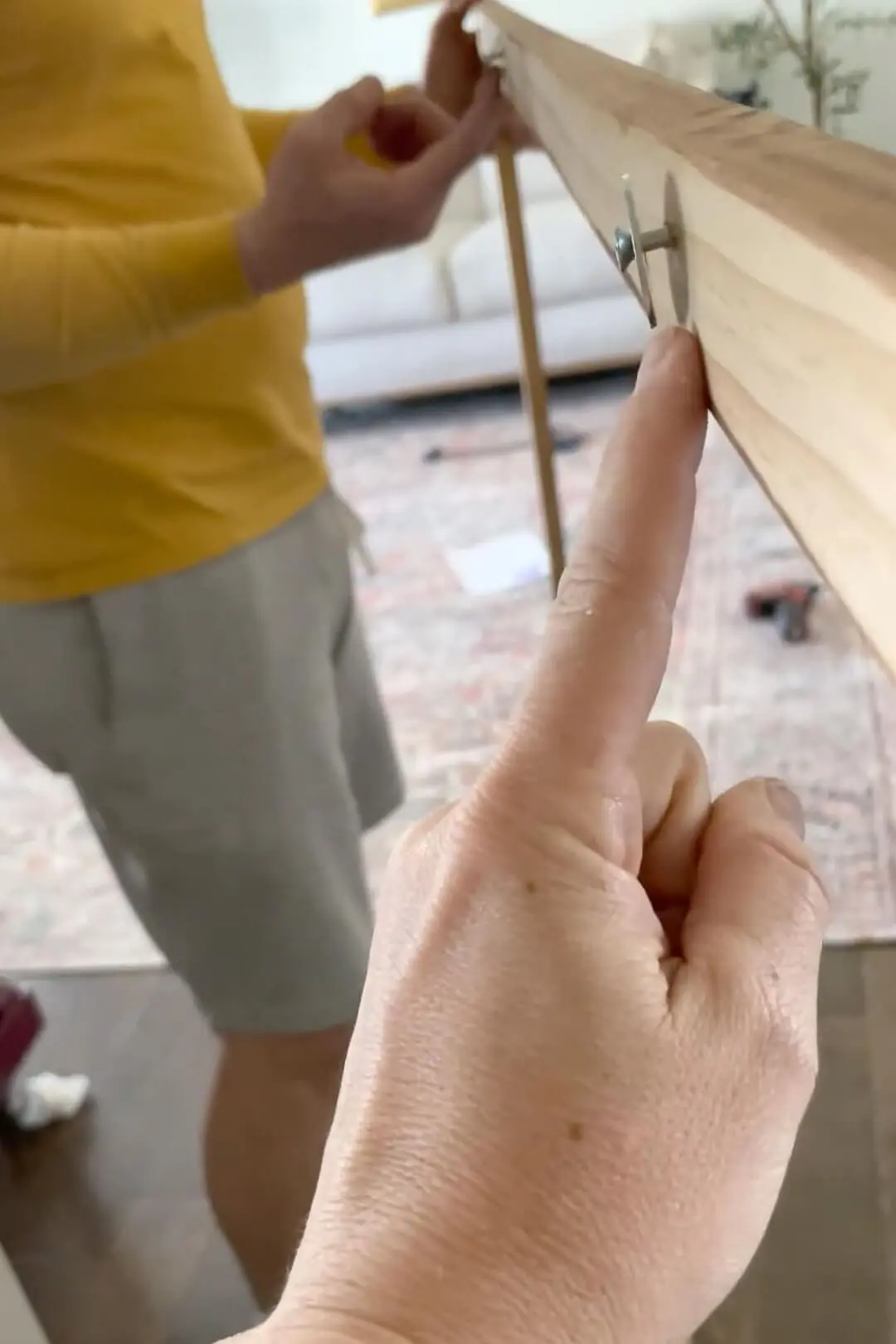 A screw and a washer attached loosely to the back of a frame. 