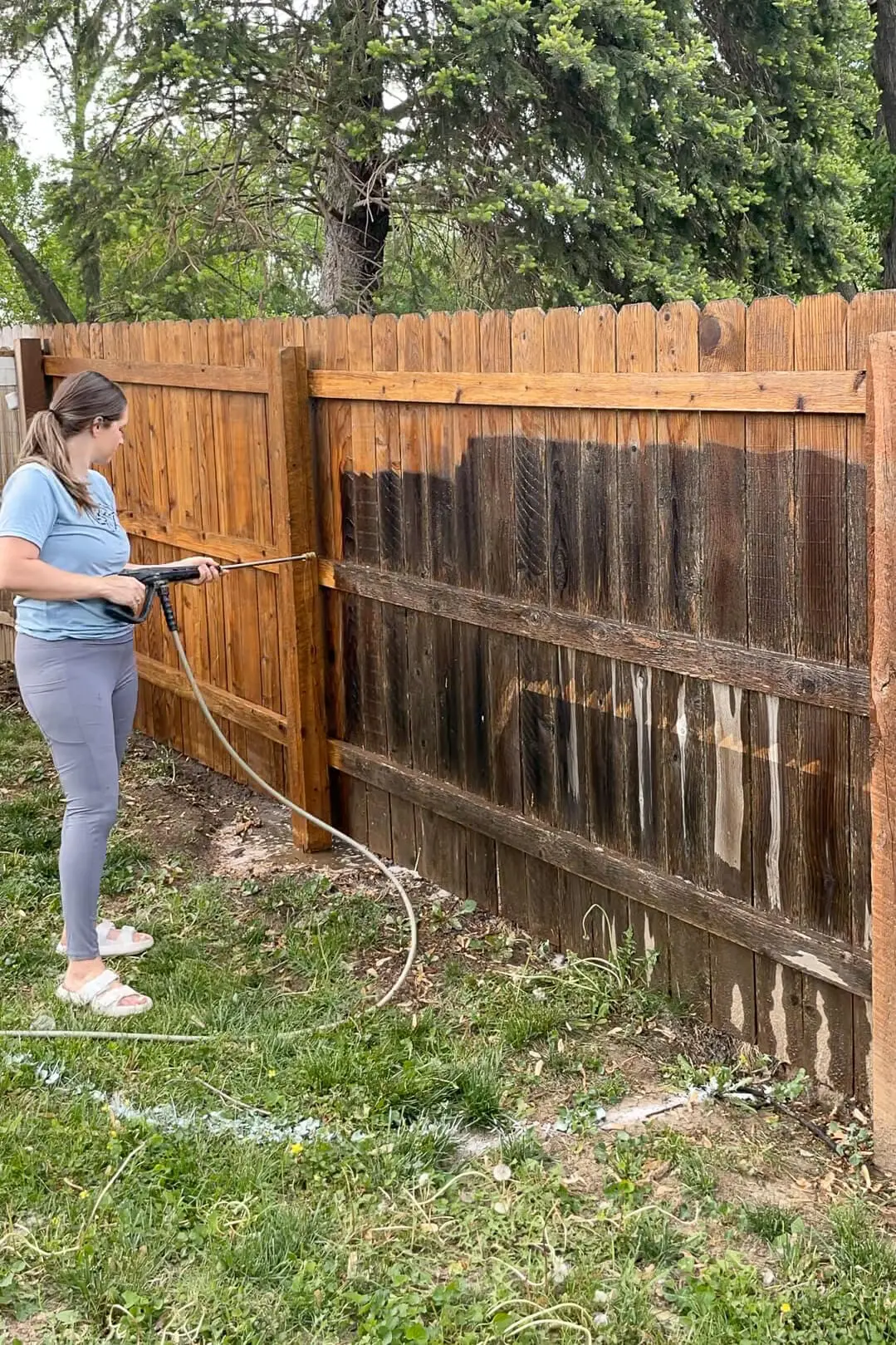 Pressure washing an old wood fence.