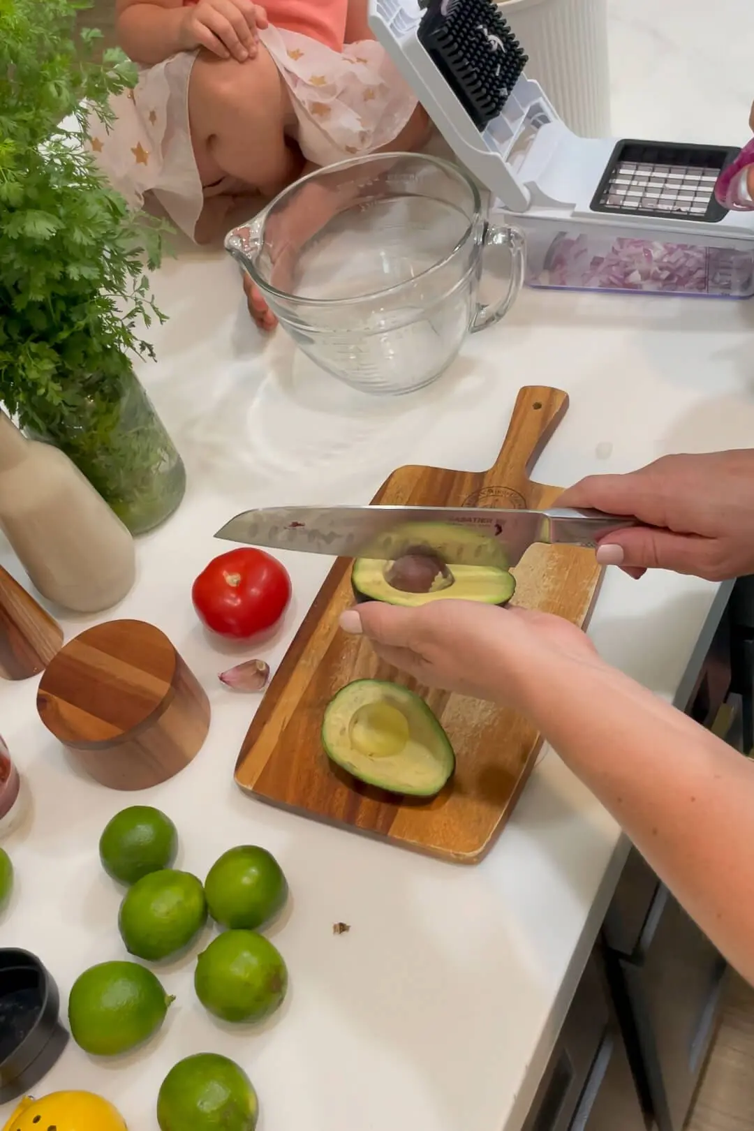 Cutting an avocado in half and removing the pit. 