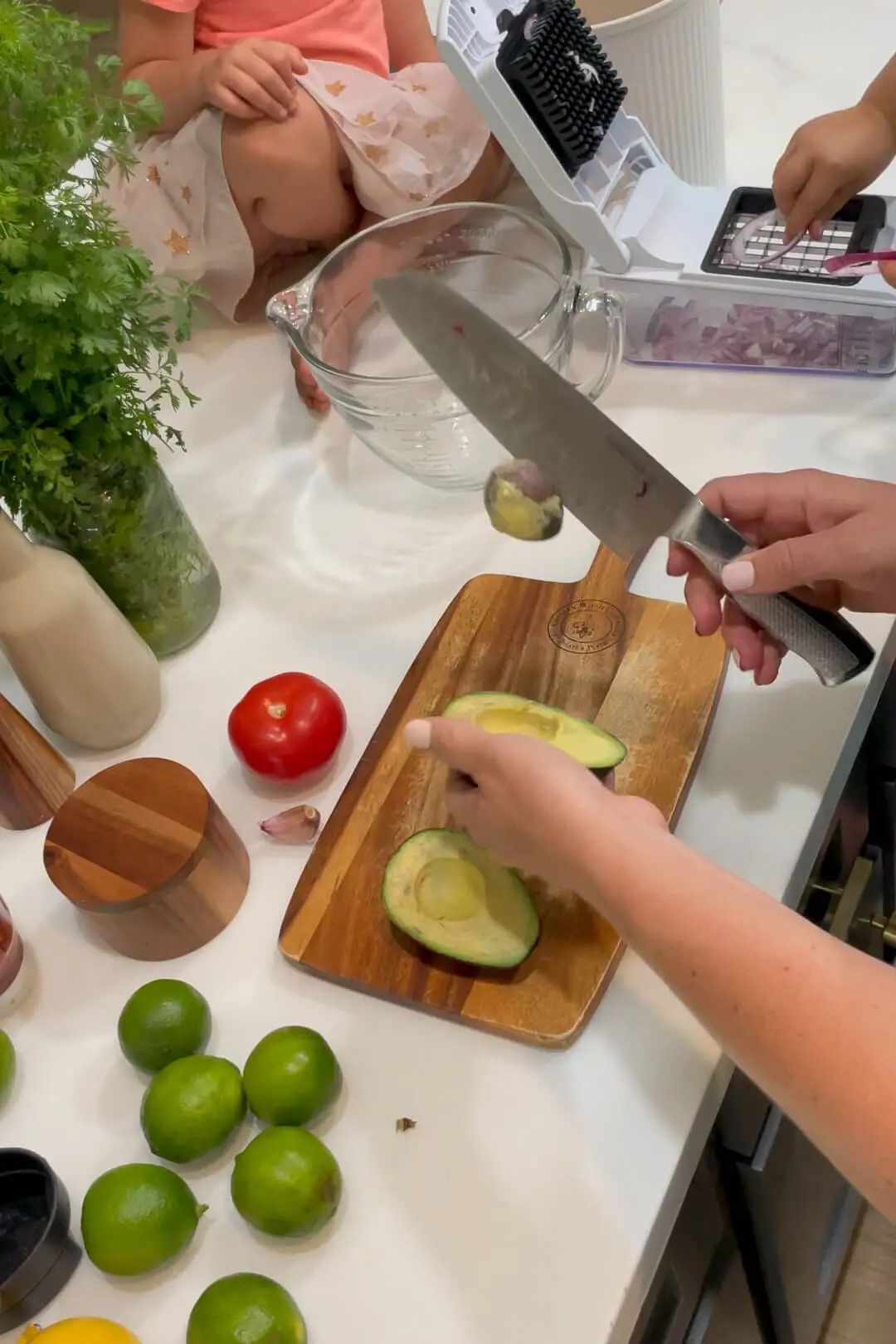 Cutting an avocado in half and removing the pit. 