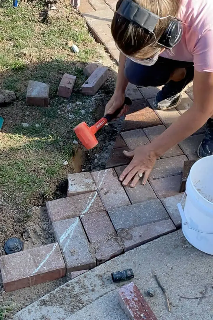 Adding cut pavers to a curved paver driveway.