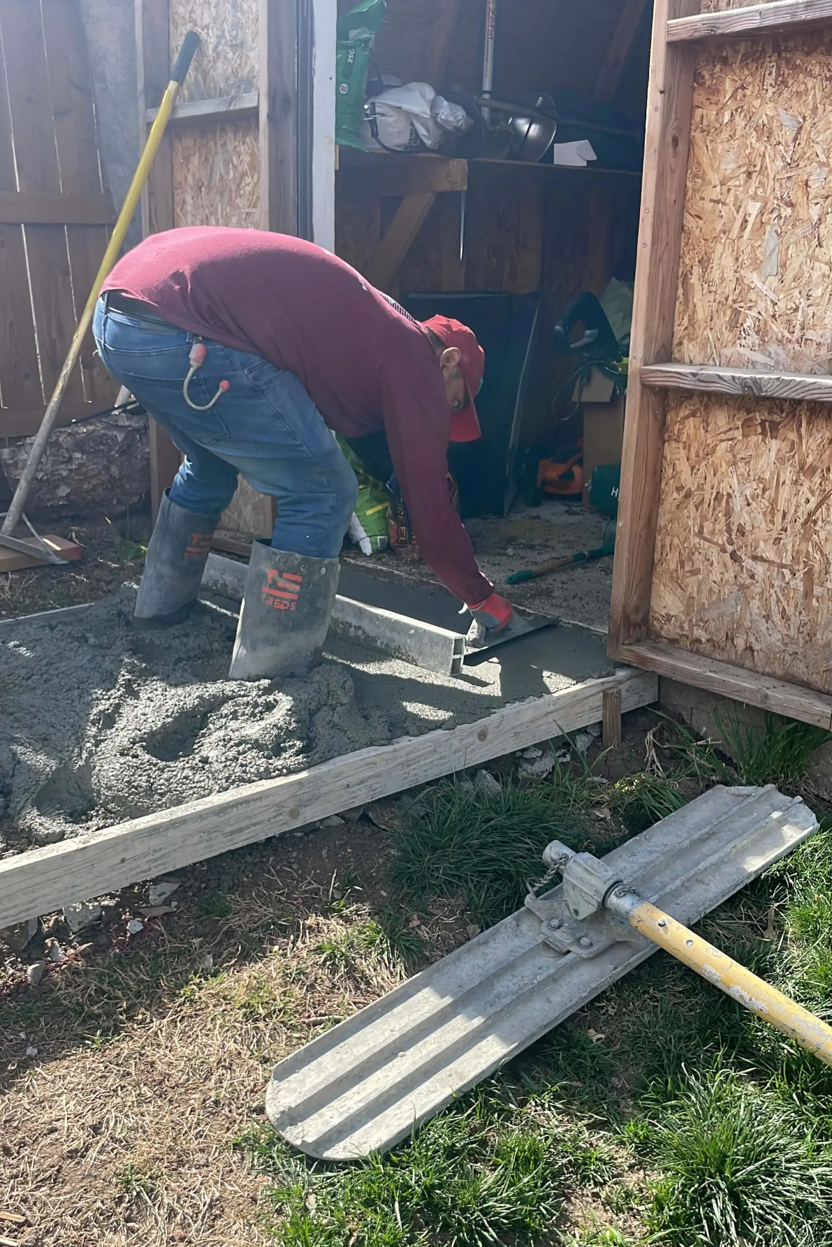 Spreading concrete for a sidewalk.