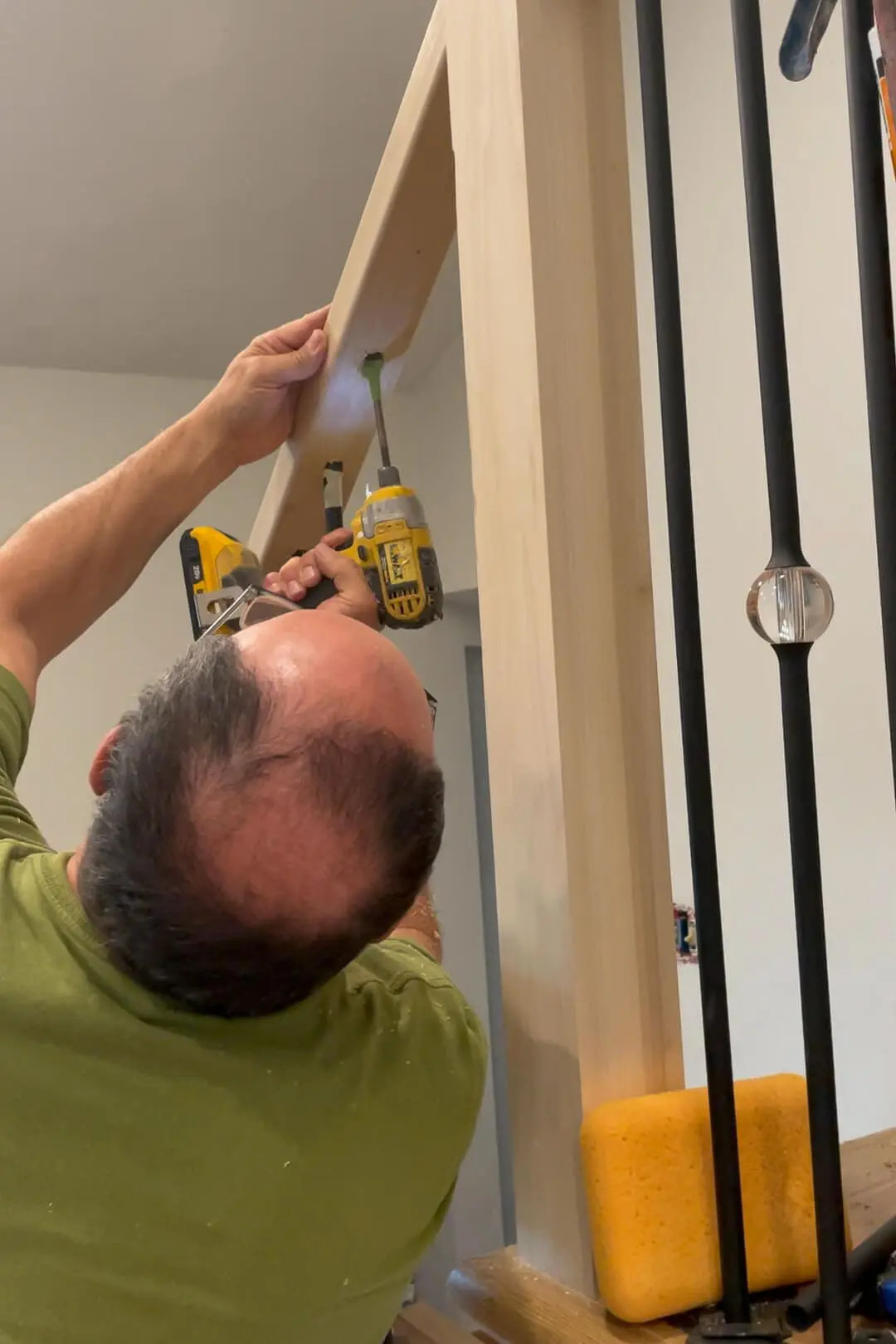 Drilling holes to install balusters on stairs. 