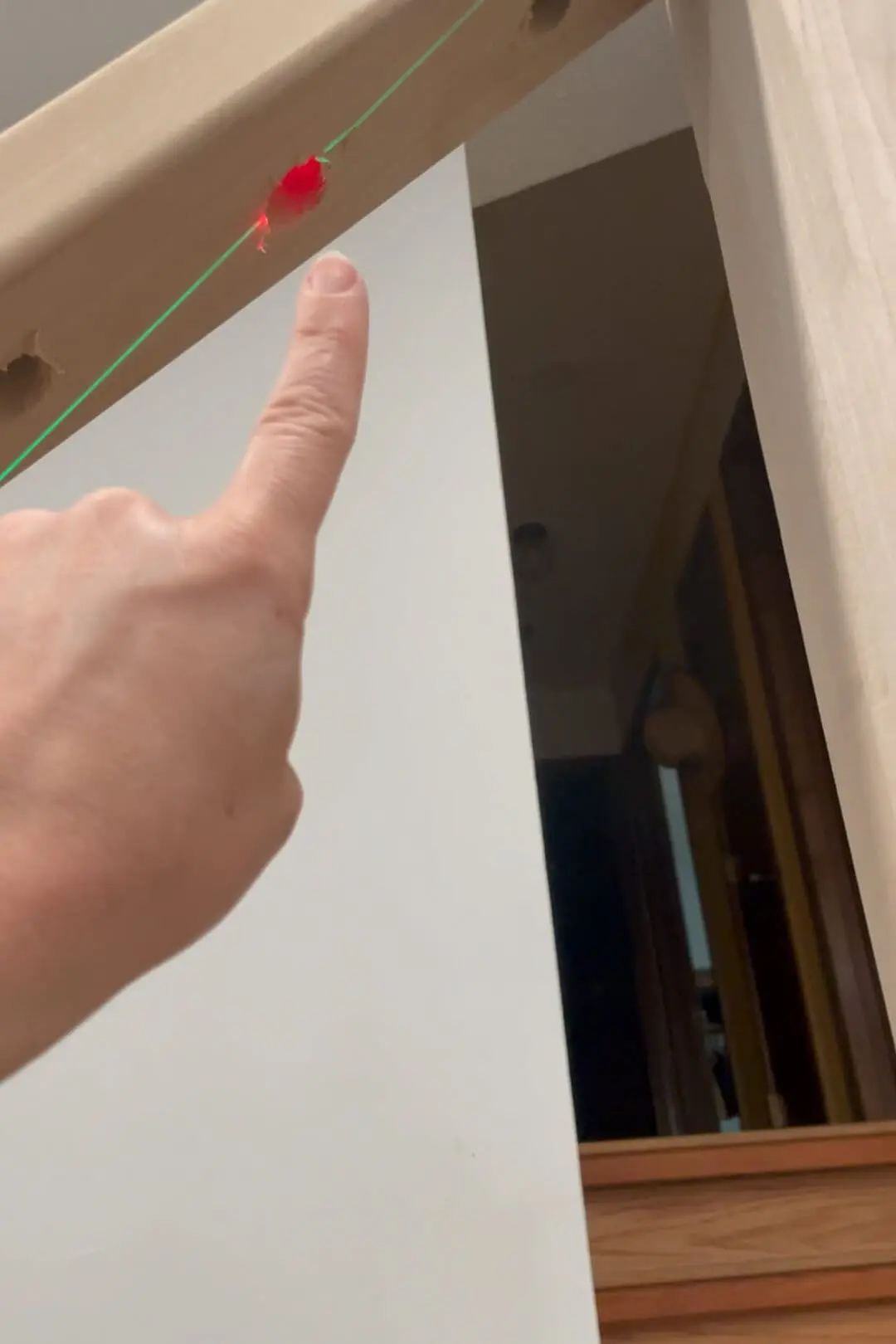 Using a laser level to install balusters in a staircase.