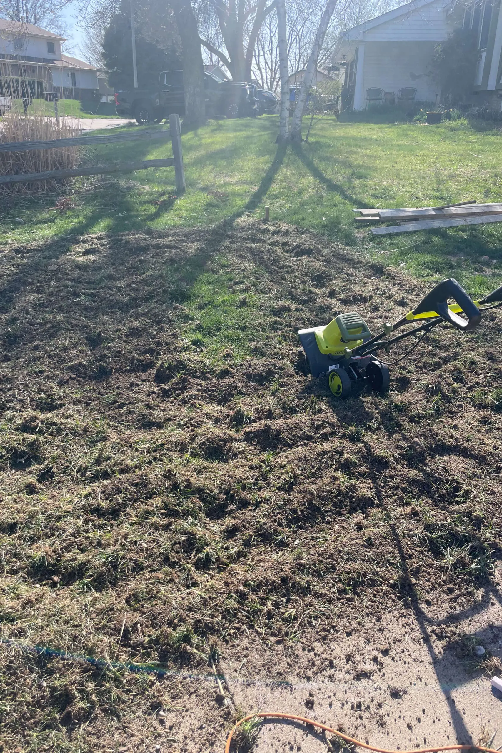 Using a tiller to dig down in the ground before installing a paver patio.