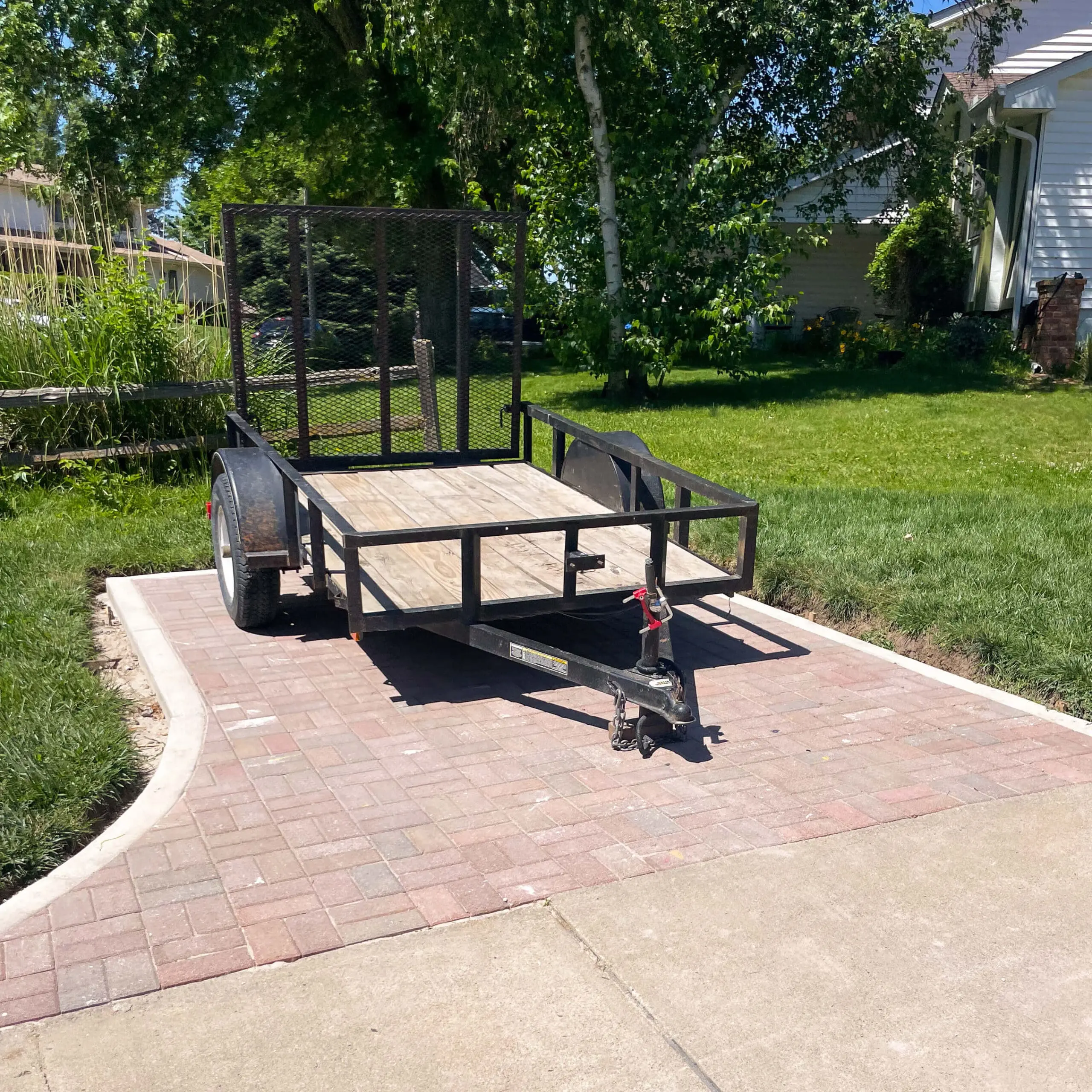The after photo of a DIY paver patio built for trailer parking.