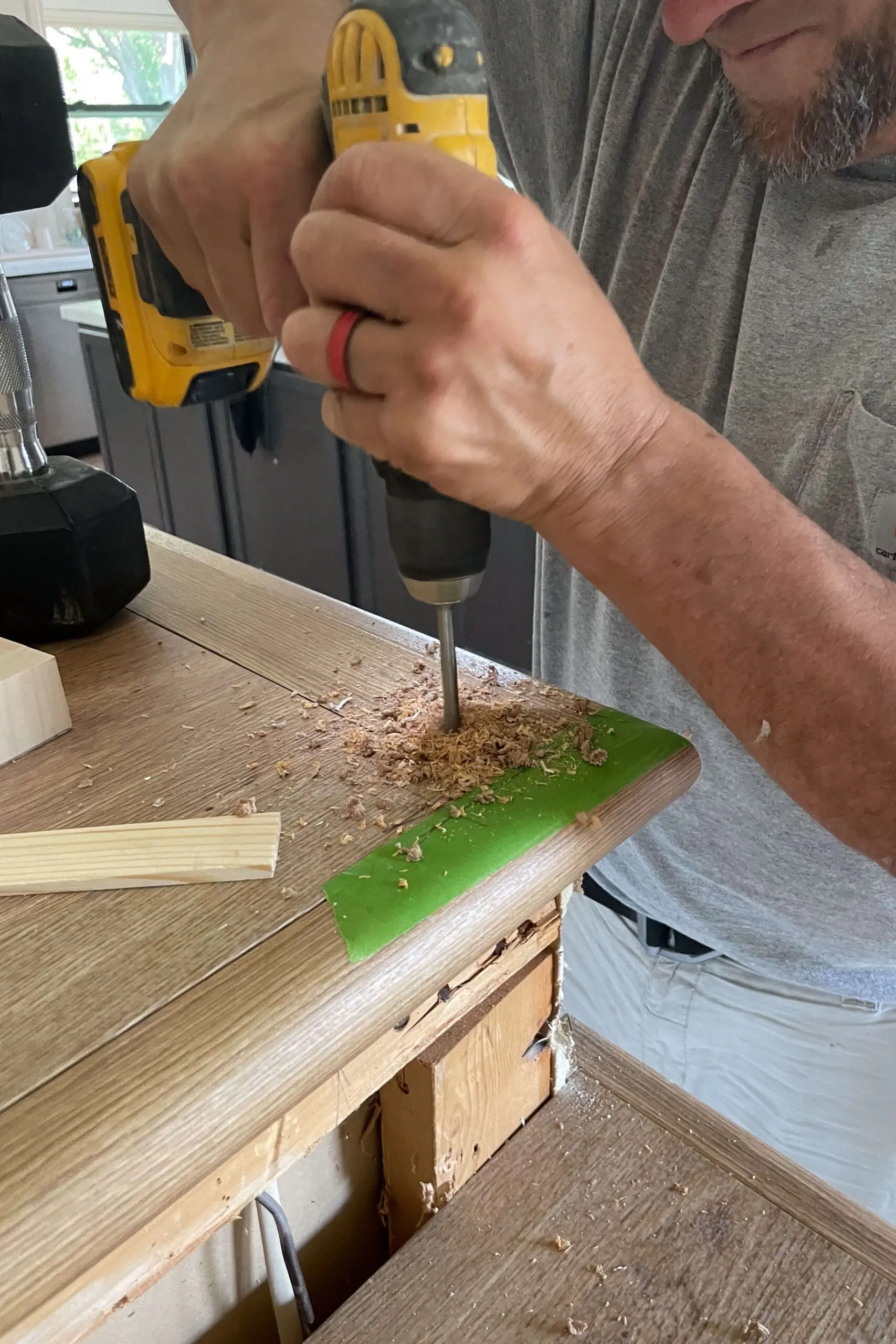 Drilling a hole in stairs to install a newel post.