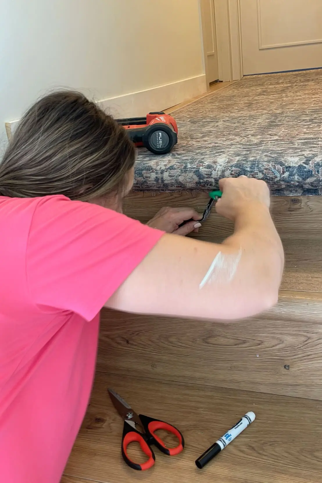 Trimming extra carpet off while installing a stair runner. 