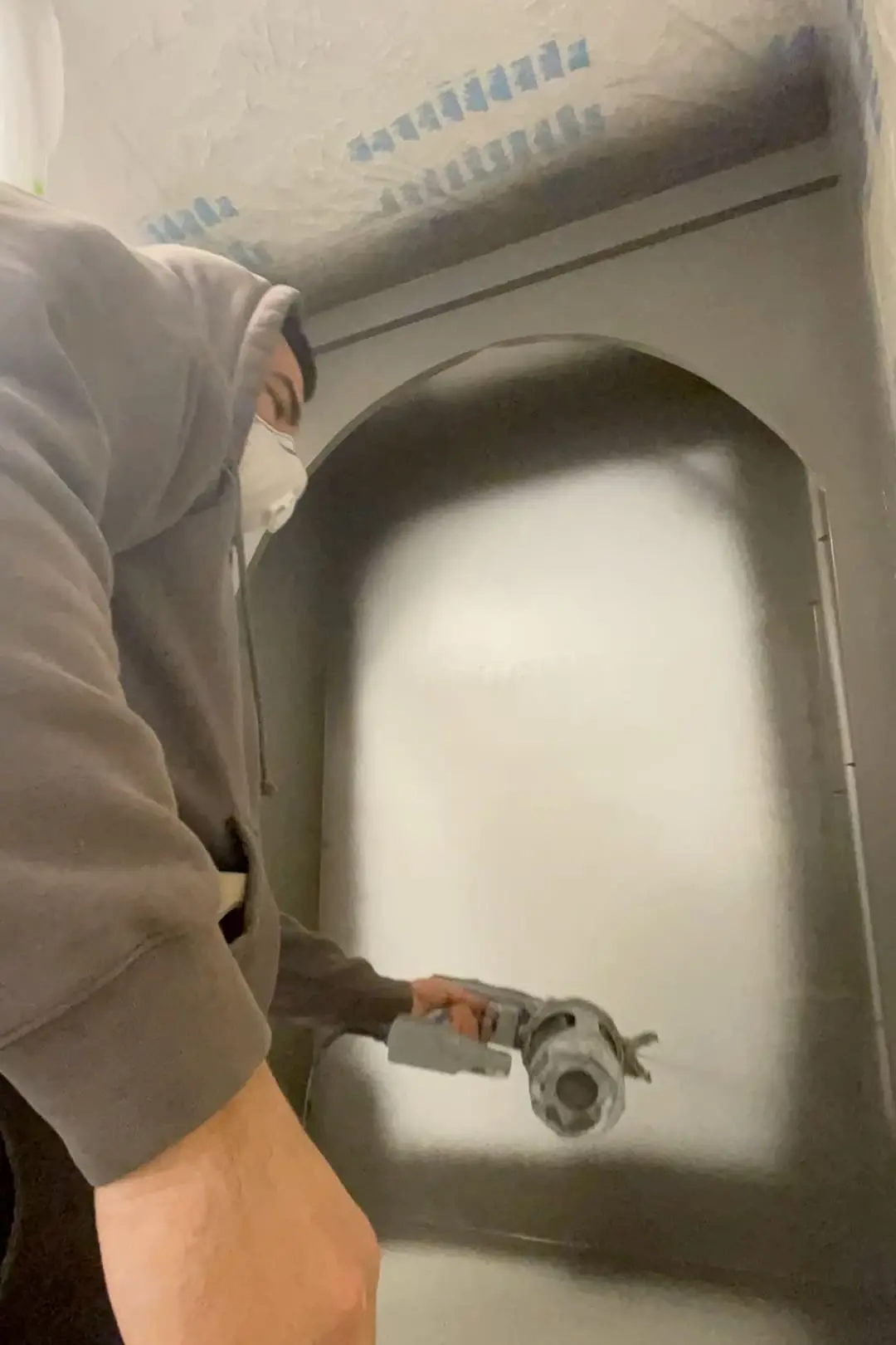 Using a paint sprayer on shelves.