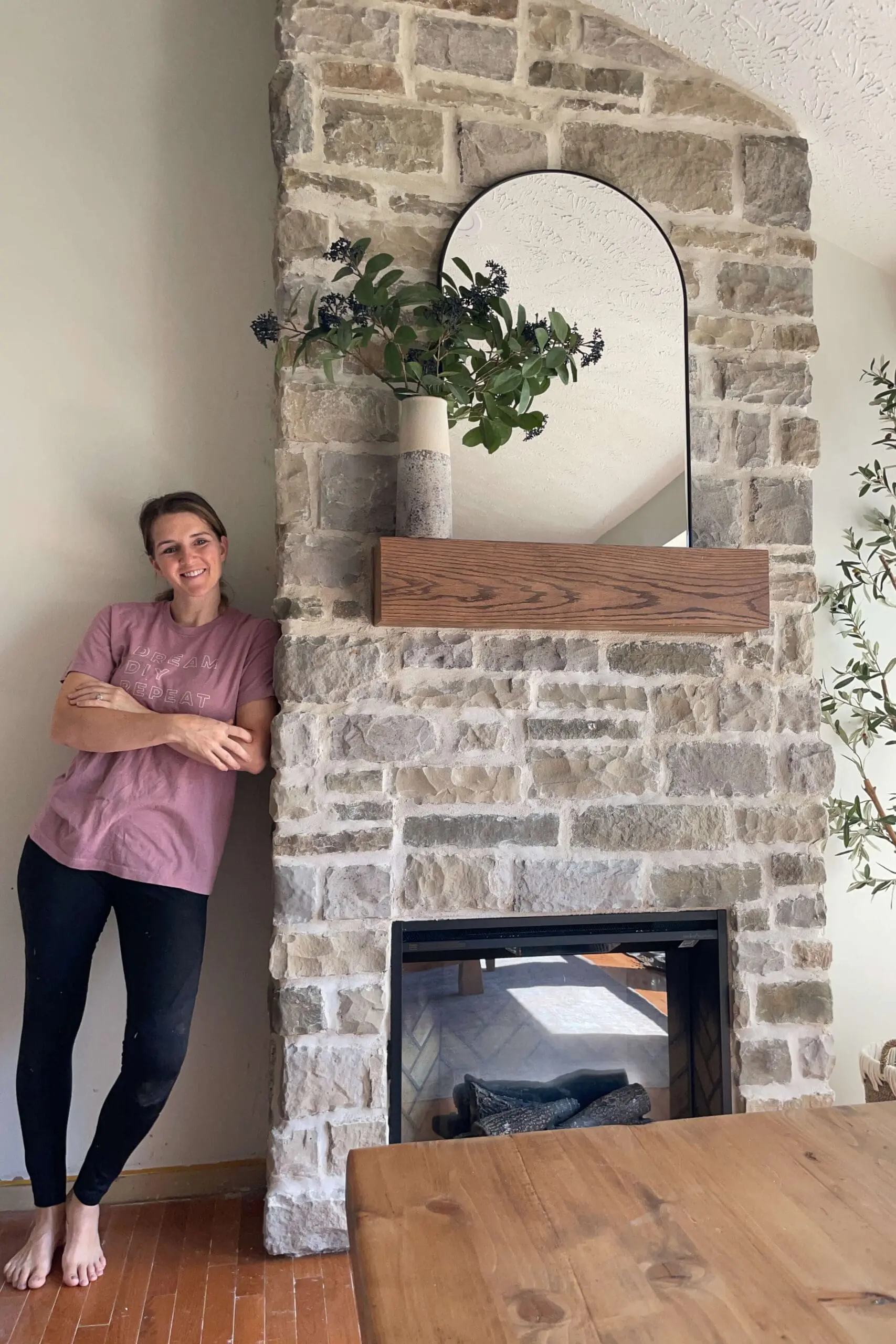 Completed DIY stone fireplace with an oak mantel, creating a cozy focal point in the dining room.