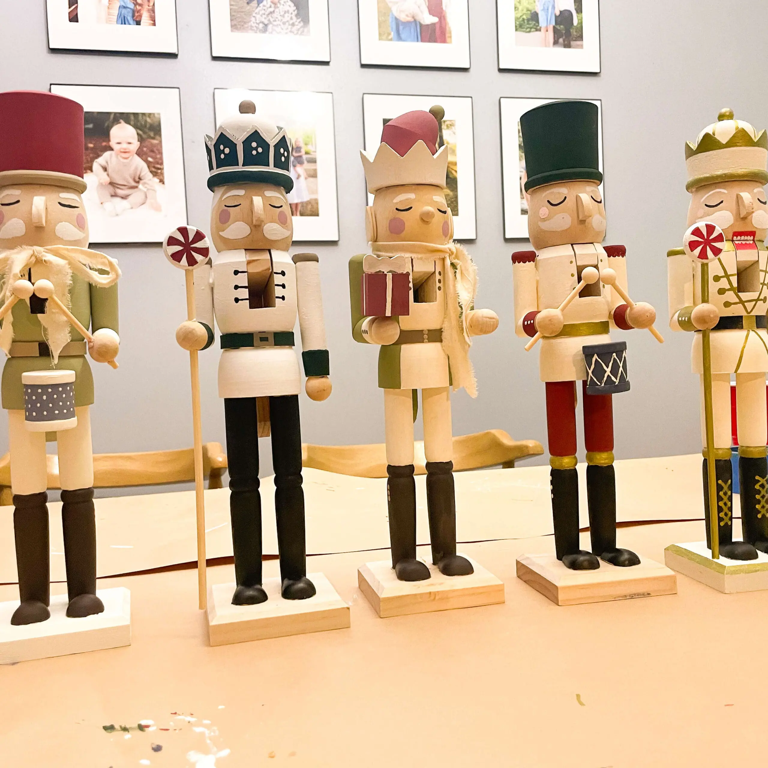 A lineup of uniquely painted wooden nutcrackers displayed on a table, showcasing creative designs from a nutcracker painting project.