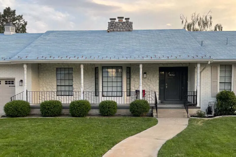Front view of a single-story home with freshly painted black railings and classic posts, showcasing a clean and modern update that boosts curb appeal.