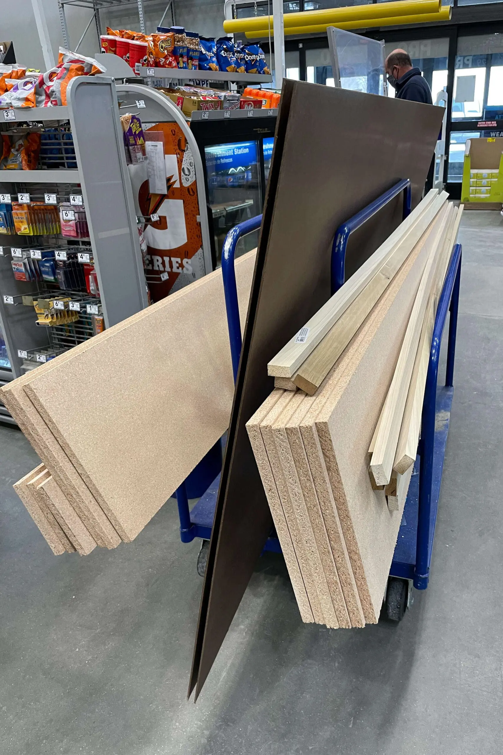Cart loaded with MDF boards, plywood, and trim pieces all cut for me at a hardware store, ready for a DIY project.