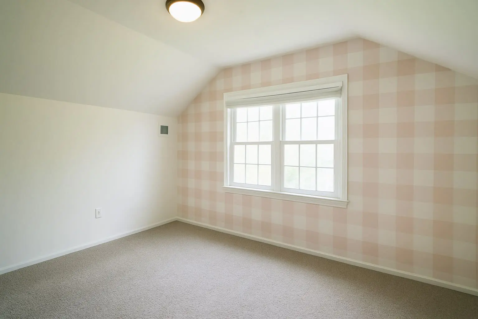 DIY pink buffalo plaid feature wall in a bright girl’s bedroom with vaulted ceilings and soft neutral carpet