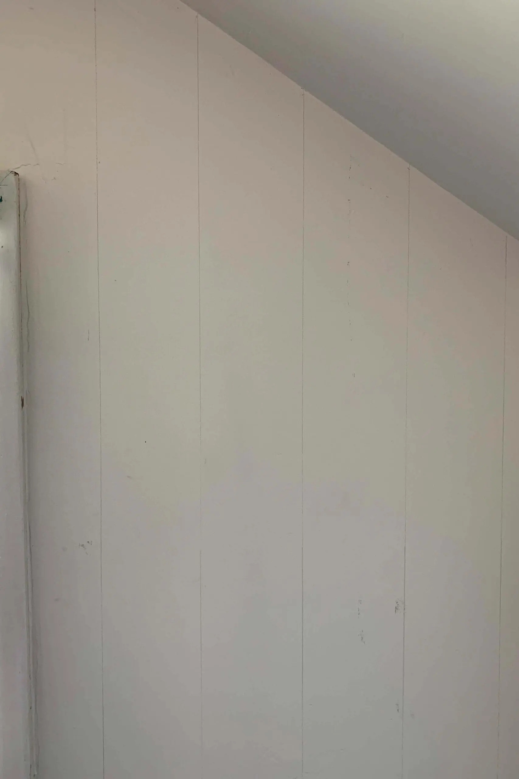 Prepping a blank angled bedroom wall before starting a DIY accent wall painting project

