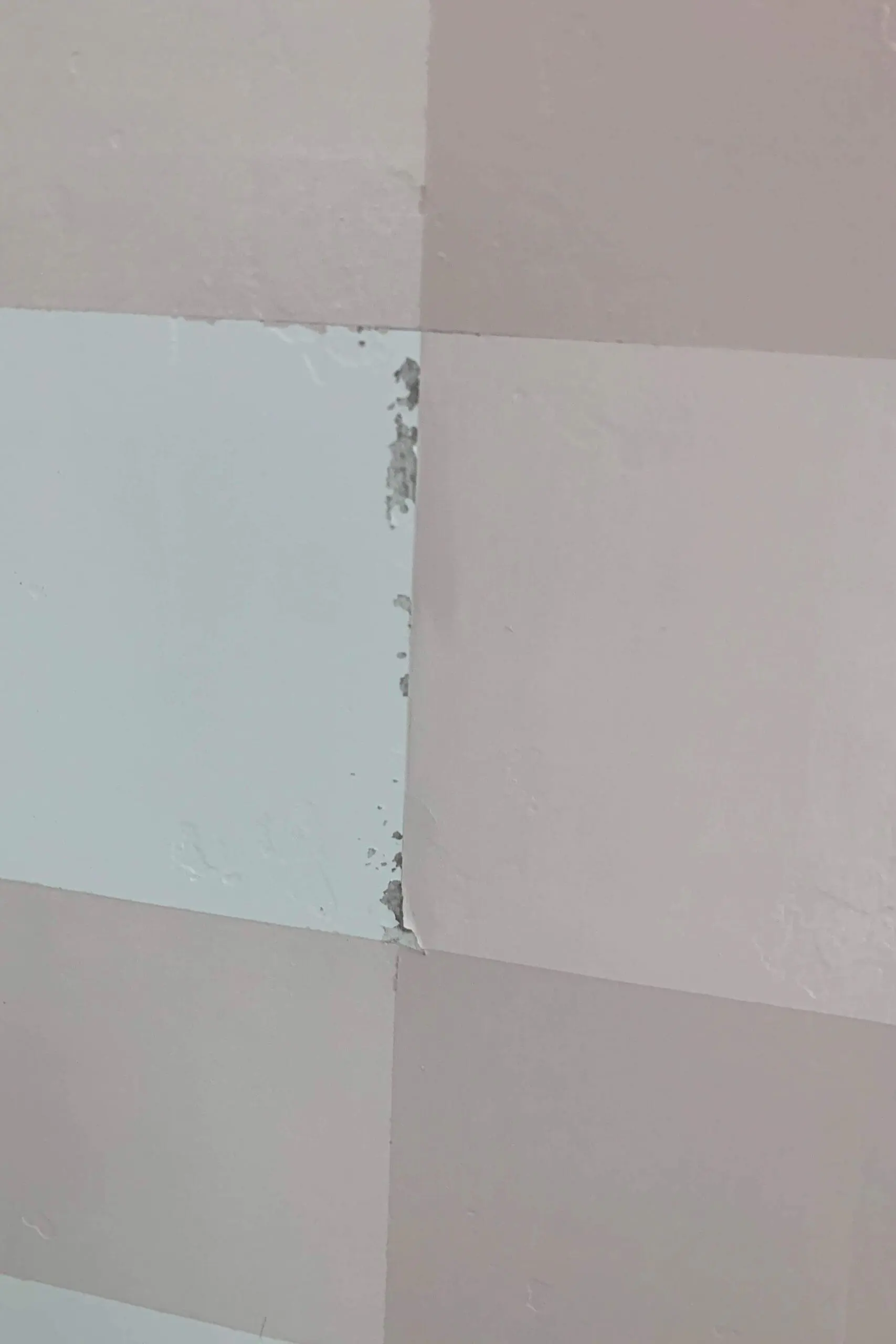Close-up of a buffalo plaid wall showing minor paint bleed and peeling along the tape lines after removing painter’s tape