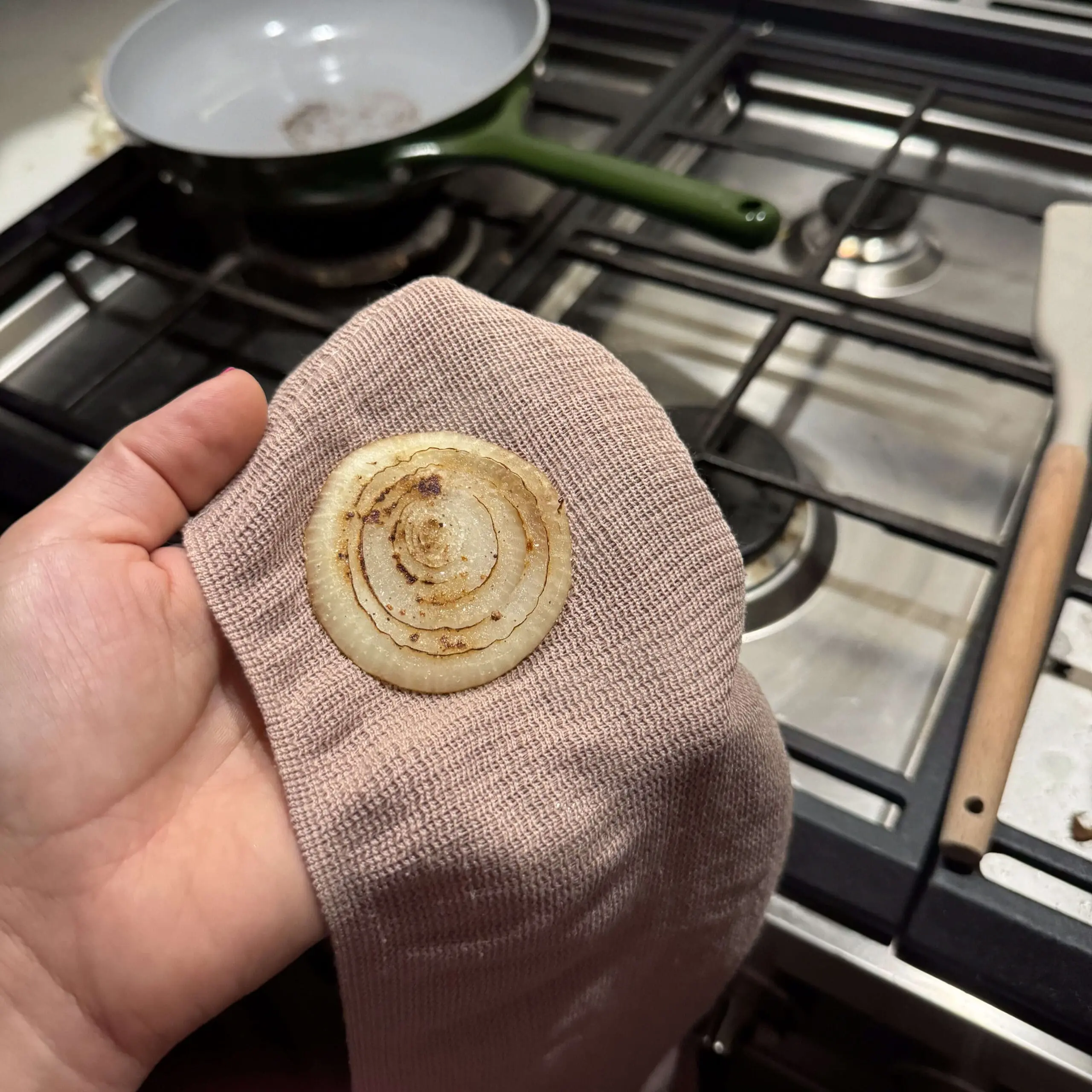 Grilled onion poultice wrapped in soft cloth, prepared on a stovetop for a natural cough remedy.