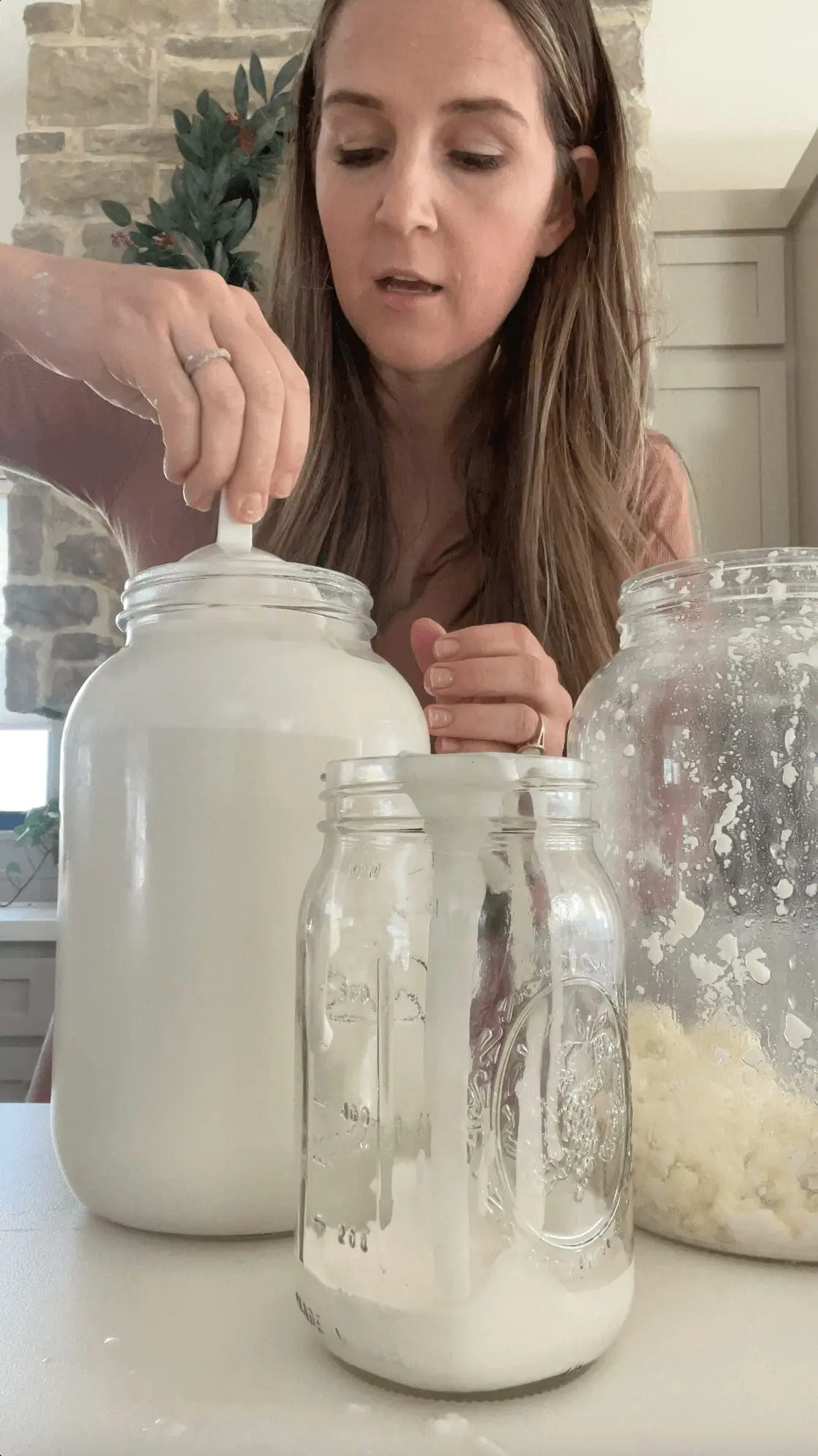 Scooping the thick cream layer off the top of raw milk.