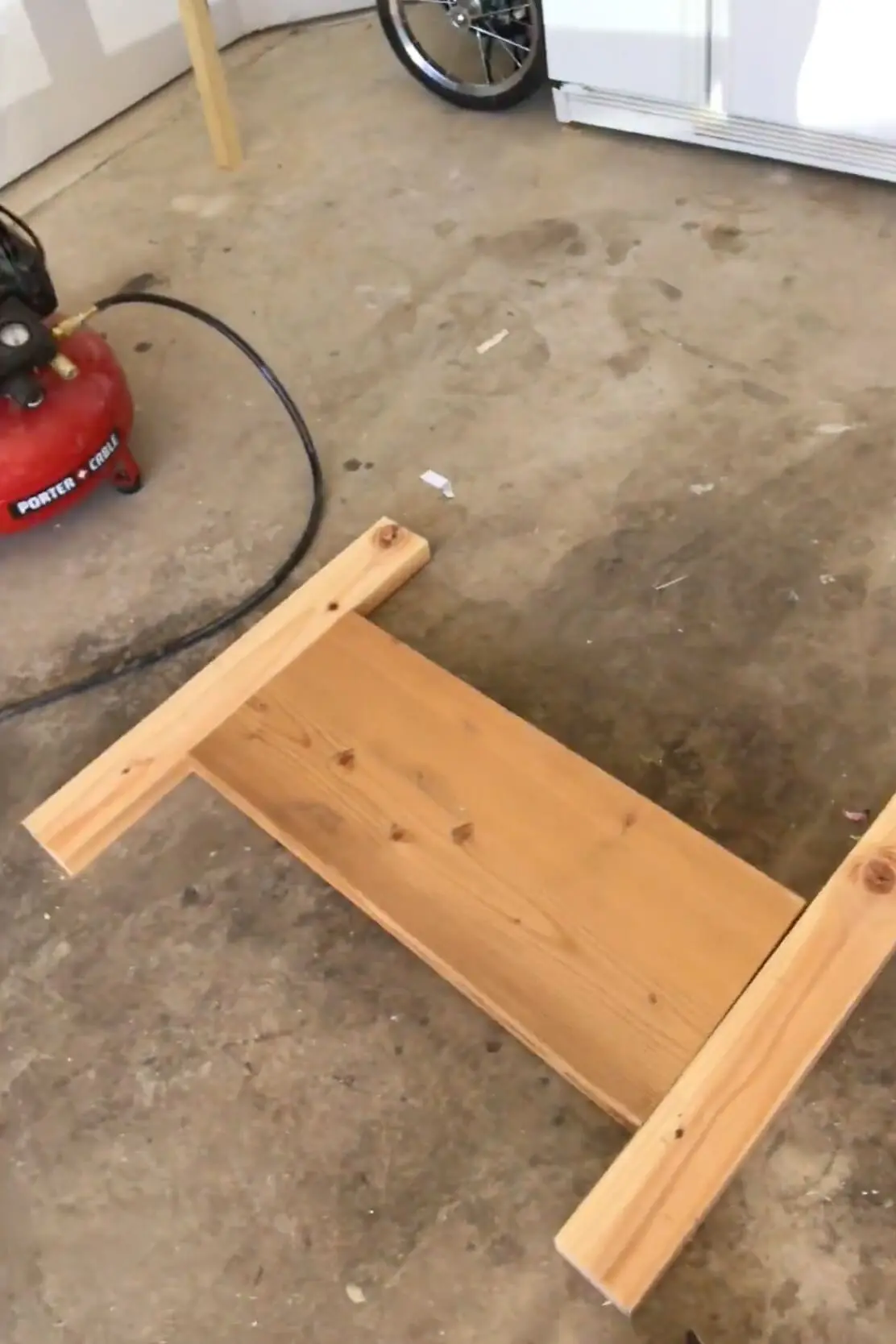 First frame pieces coming together on the garage floor during the build of a simple wooden kids bed.