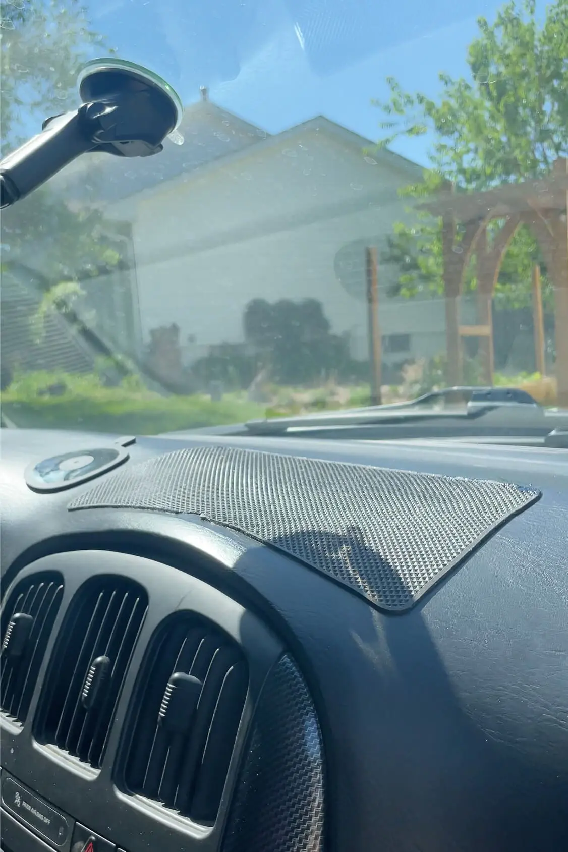 Sticky rubber grip mat placed on a car dashboard to keep phones or small items from sliding during drives.