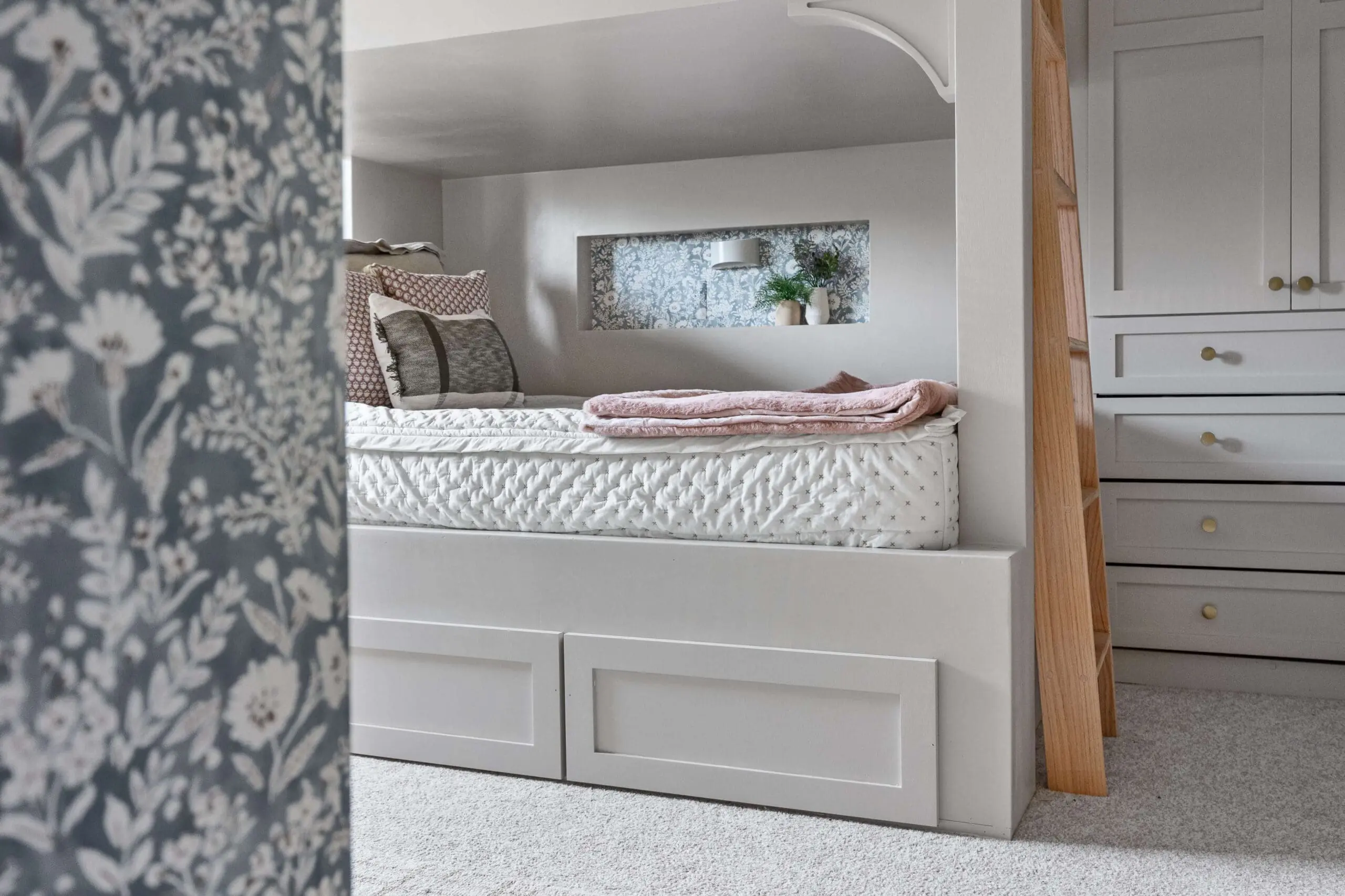 Zoomed-out view of a custom built-in bunk bed with a wallpapered wall niche, showcasing how the outlet cover blends into the wallpaper design.