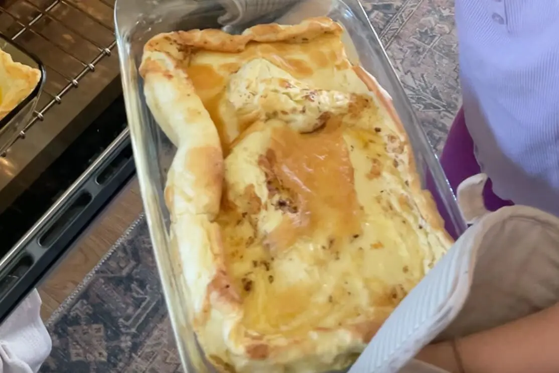 Close-up of a puffy Dutch Baby just pulled from the oven, golden and crispy around the edges.