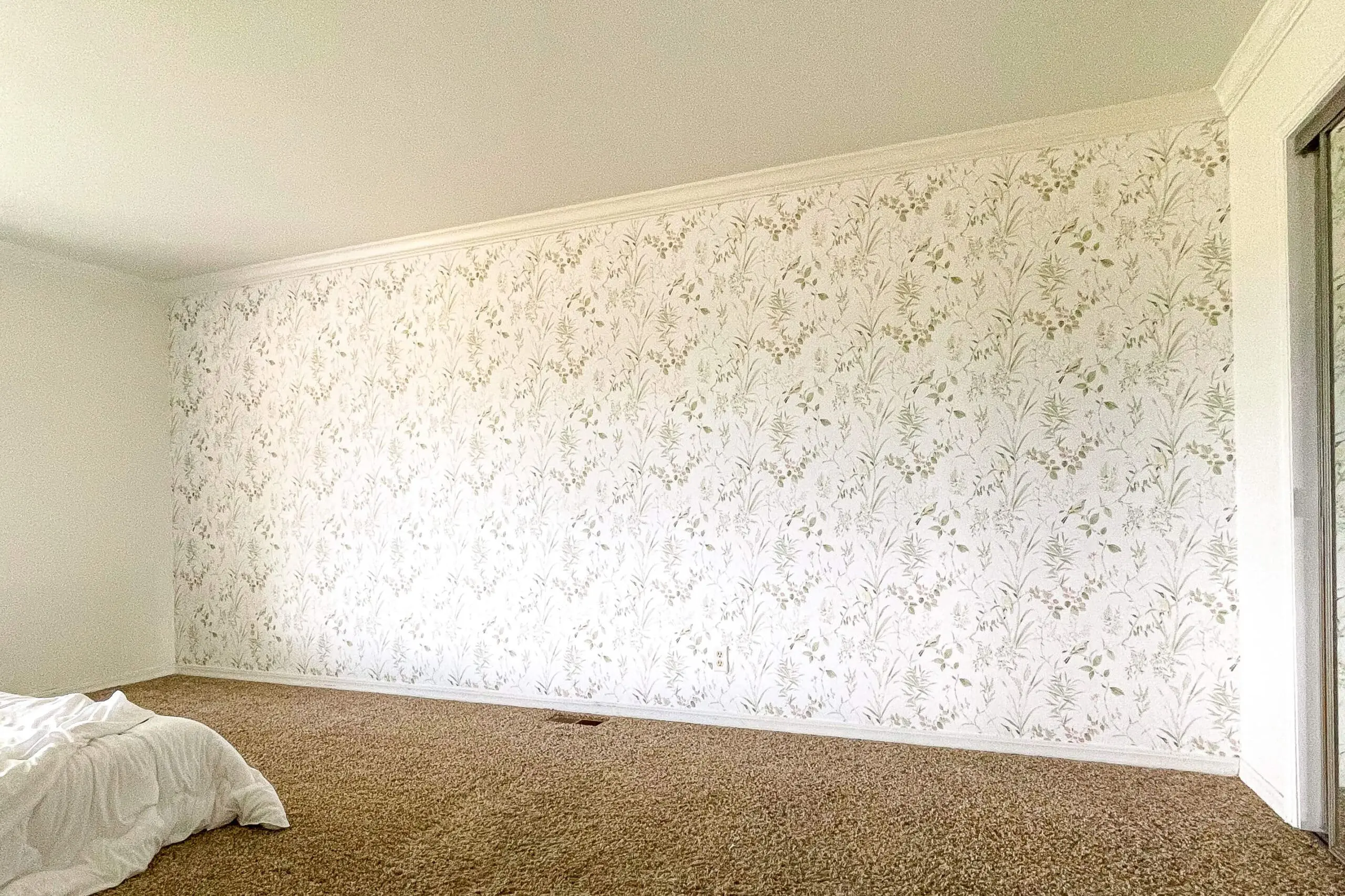 Full view of a completed bedroom feature wall with traditional botanical wallpaper