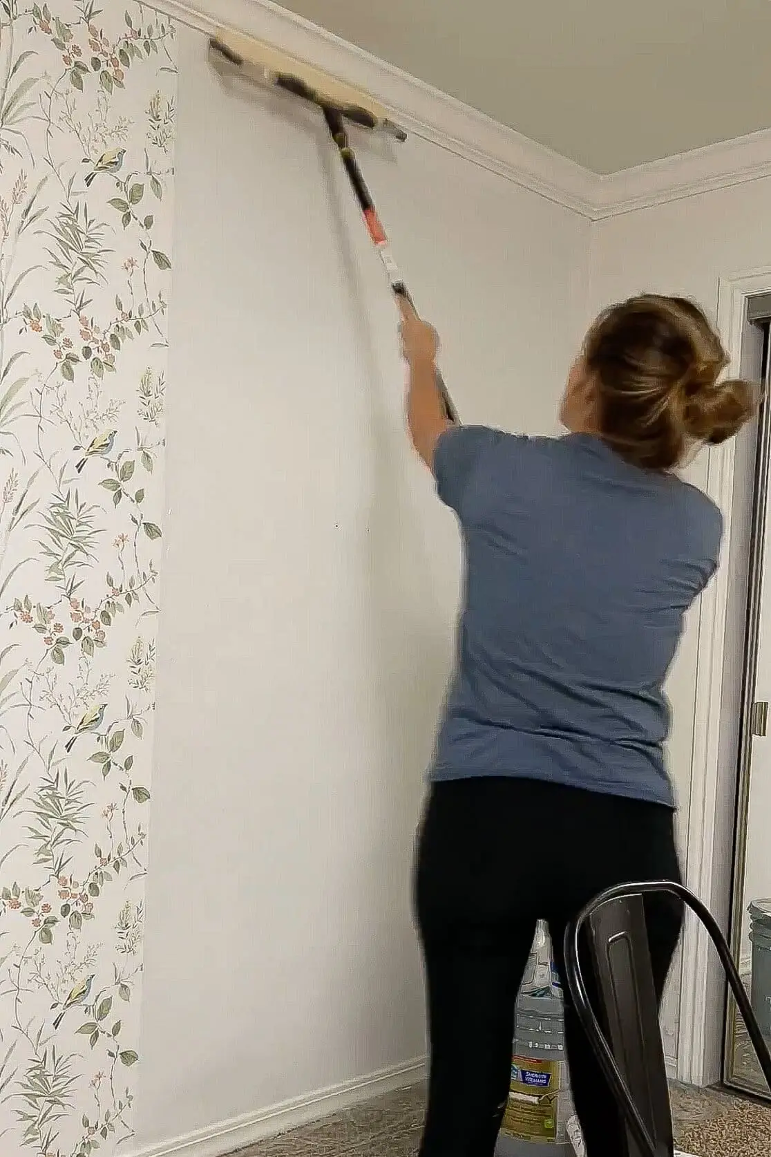 Rolling paste onto the wall.