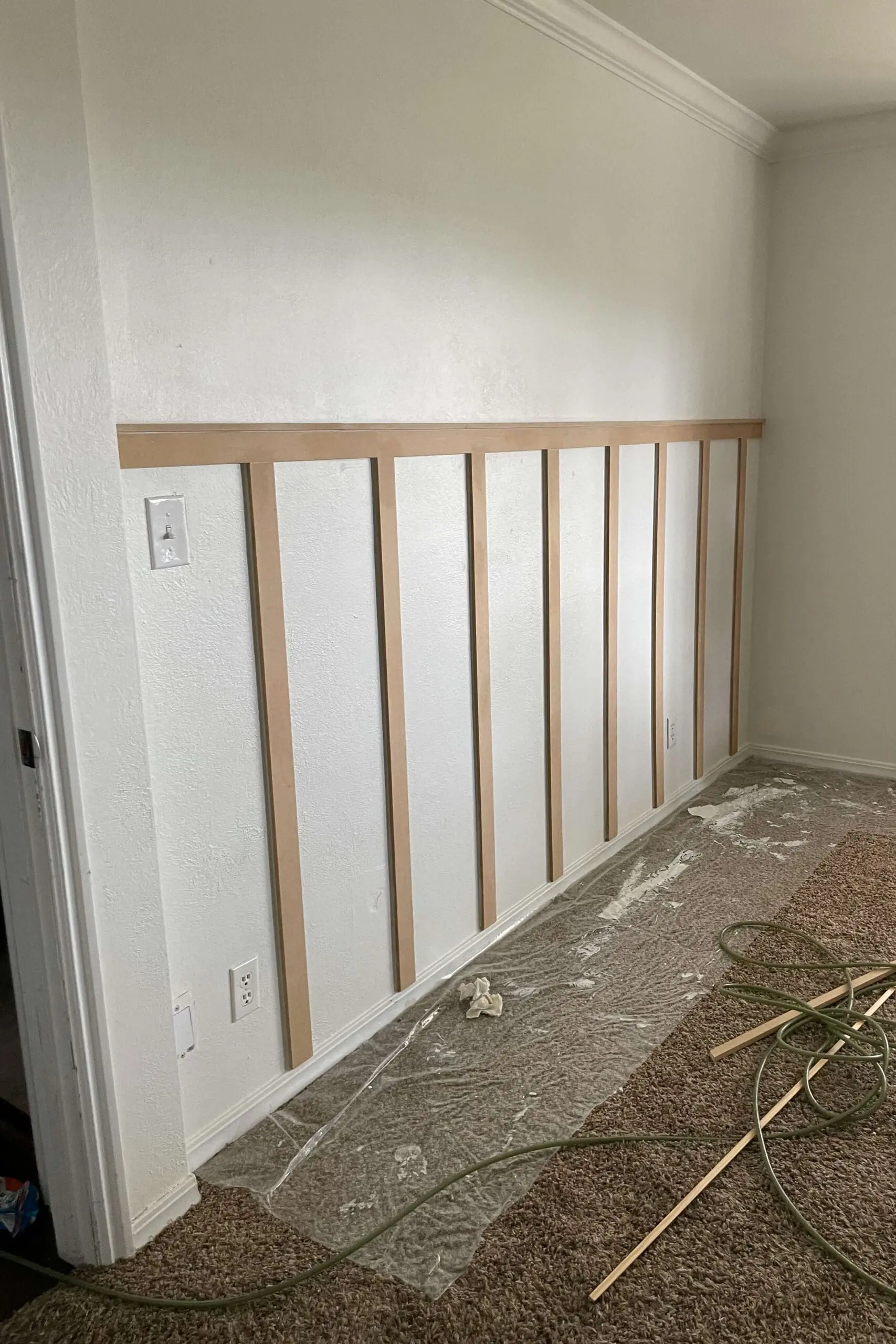 Board and batten wall fully installed and ready for primer and paint, showing clean lines and symmetrical spacing.