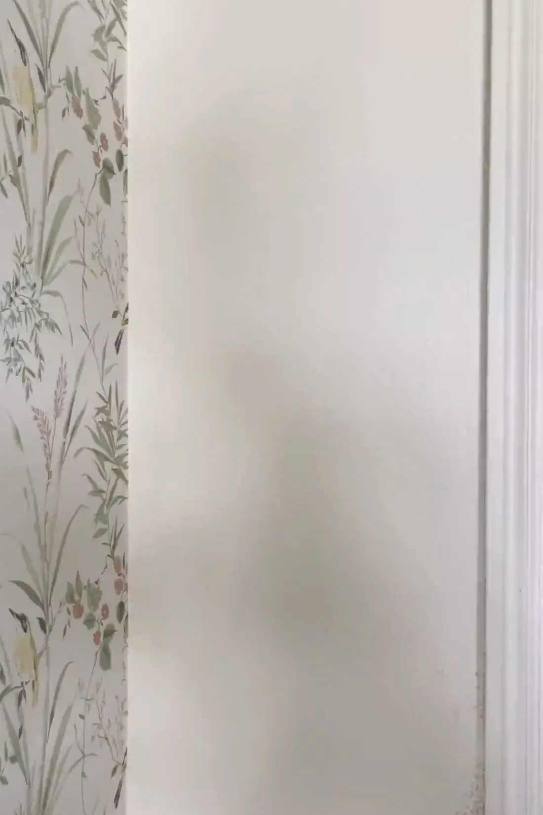 Clean wallpaper seam meeting a painted wall edge with door trim