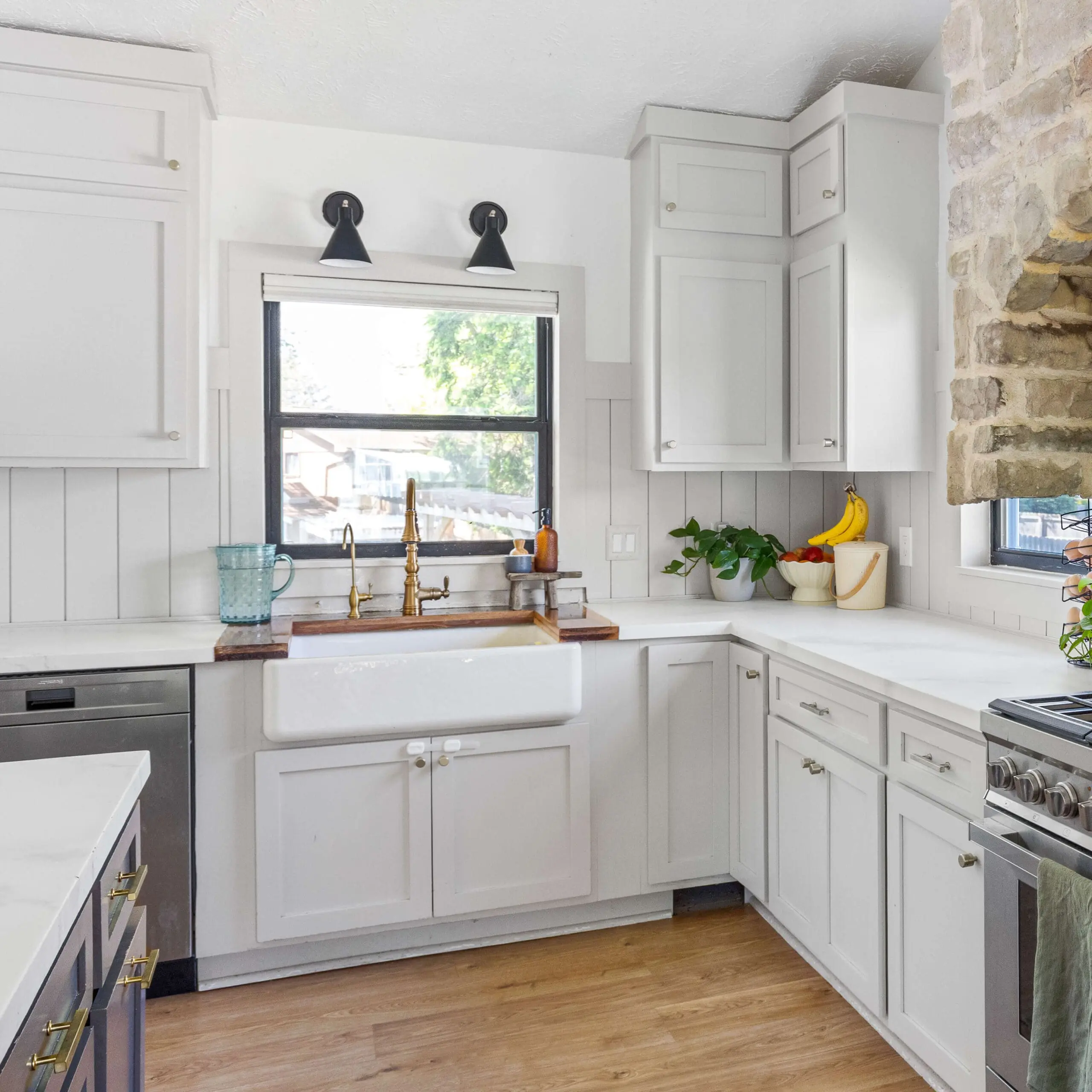 White epoxy kitchen countertops with a faux marble finish, styled with gold faucet, farmhouse sink, and white shaker cabinets