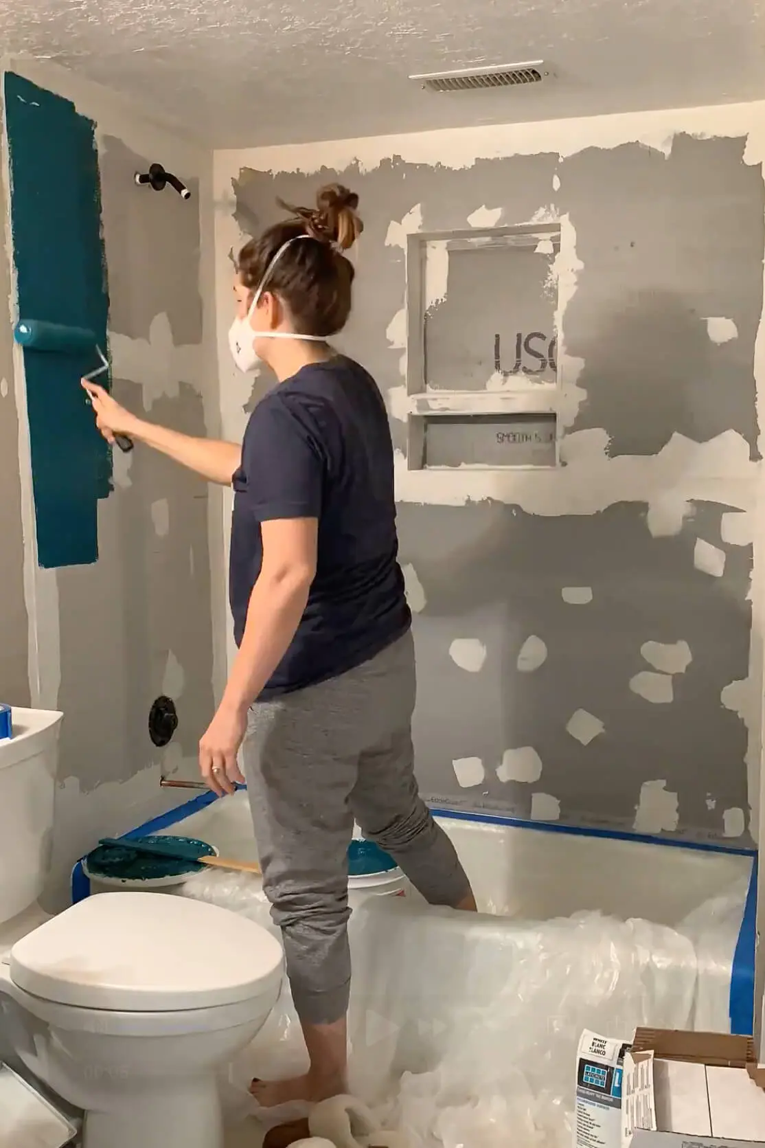 Applying a liquid waterproofing membrane to shower walls and niche to create a sealed, watertight surface.