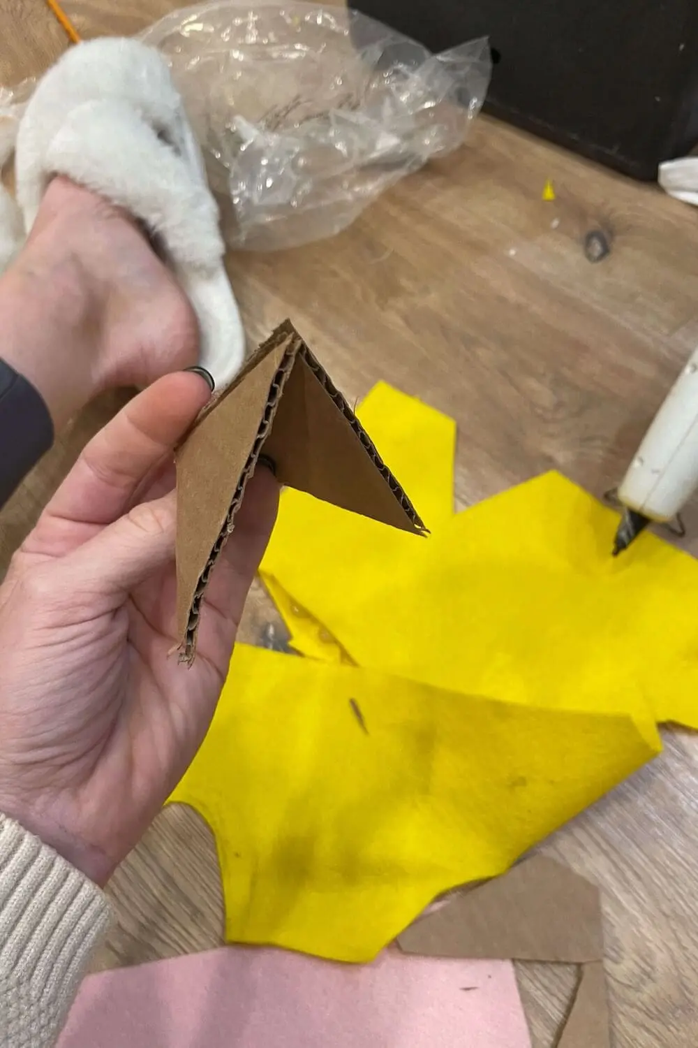 Cardboard triangle pieces used to build a felt beak for a DIY chicken costume.