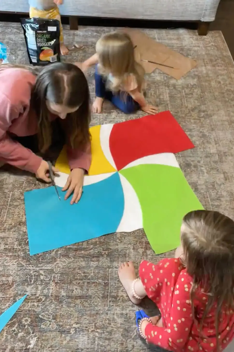Cutting colorful felt pieces to form the swirl design for a DIY lollipop candy costume.