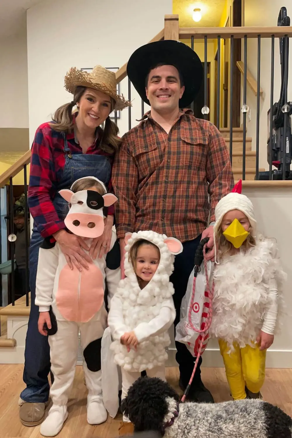 Family barnyard Halloween costumes—parents dressed as farmers with kids as a cow, sheep, and chicken