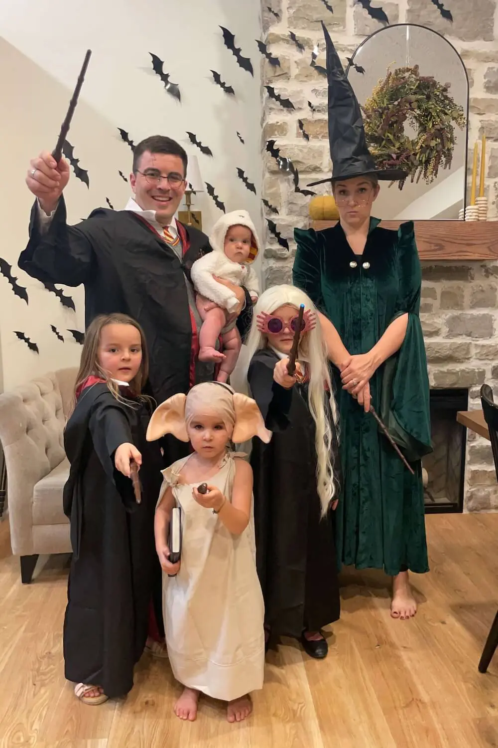 amily in Harry Potter themed costumes posing with wands, including Harry, Hermione, Luna Lovegood, Dobby, Hedwig, and Professor McGonagall.