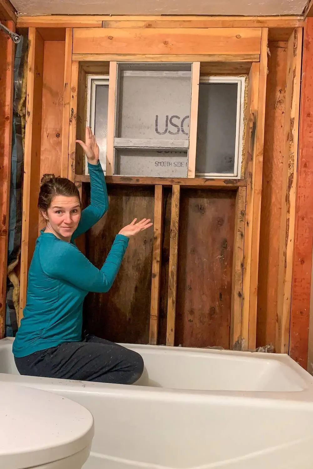 Wooden shower niche frame with cement board back attached, sitting on a workbench before installation.