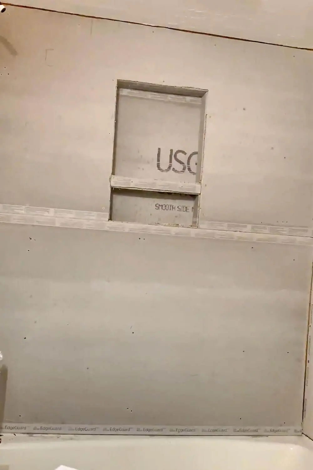 Rough framing for a shower niche installed in the wall, showing 2×4 studs and niche cavity before backer board.
