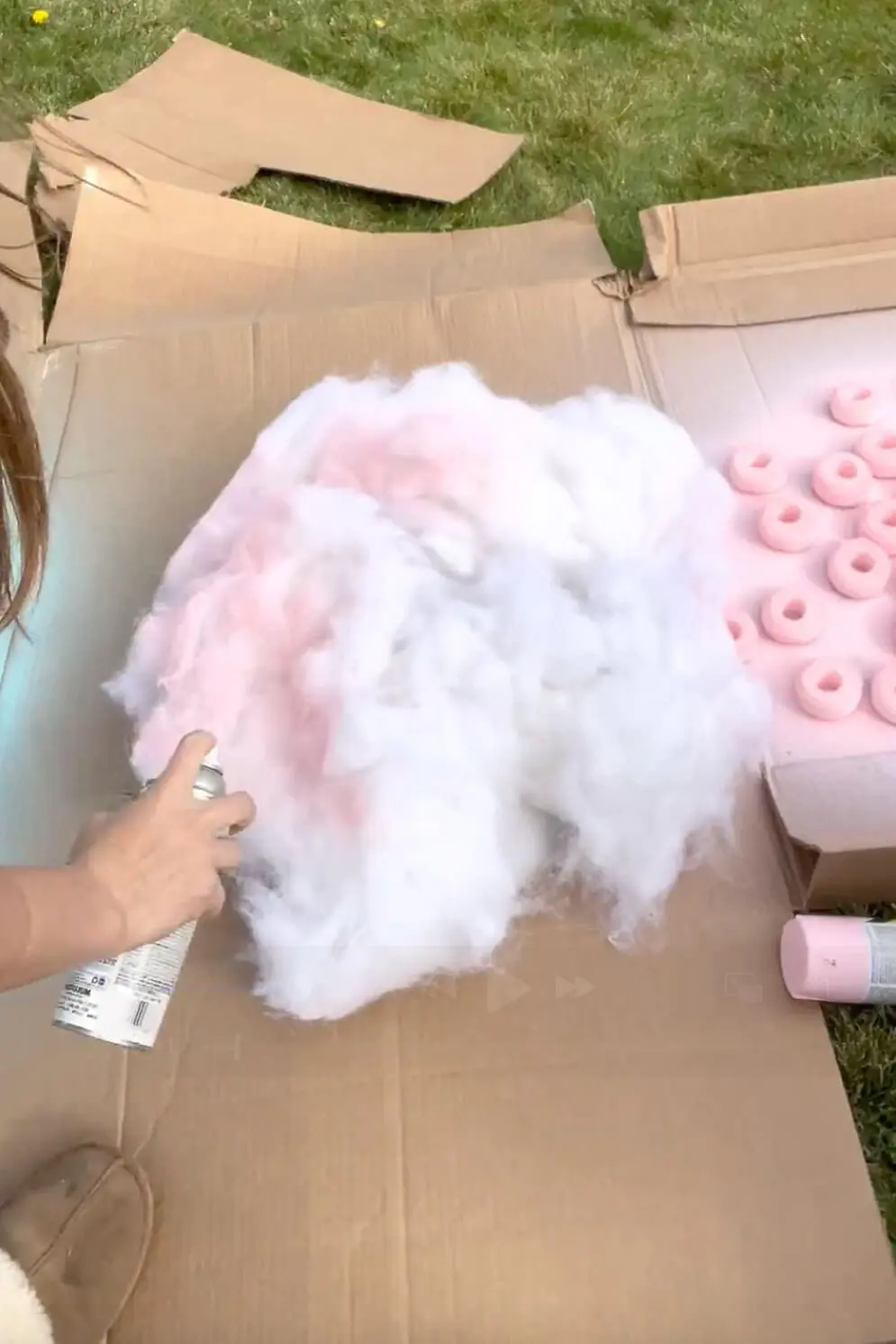 Spray painting polyester batting pink to create fluffy material for a DIY cotton candy costume.
