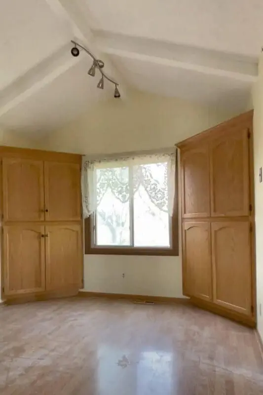 breakfast nook before remodel with oak built-in cabinets and lace curtain