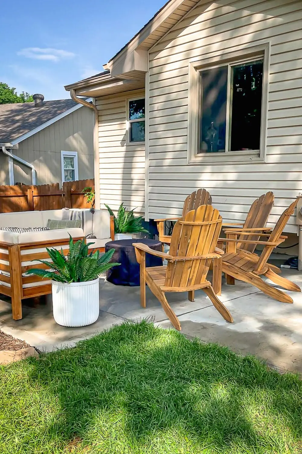 Backyard remodel after with new patio, Adirondack chairs, and landscaping