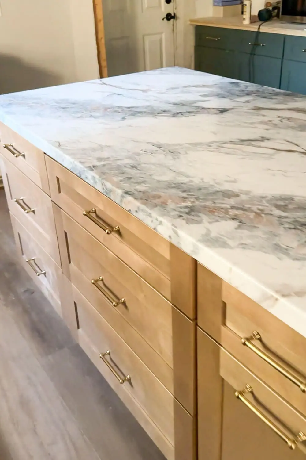 Close-up of DIY faux marble kitchen counter created with kitchen counter contact paper, highlighting smooth rounded edges and a natural marble look.