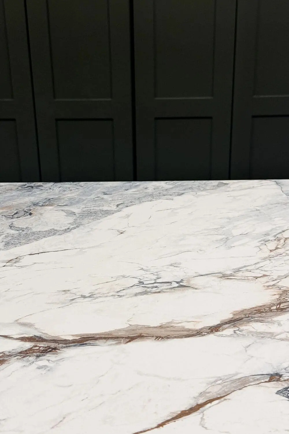 Finished DIY faux marble countertop paired with green cabinets