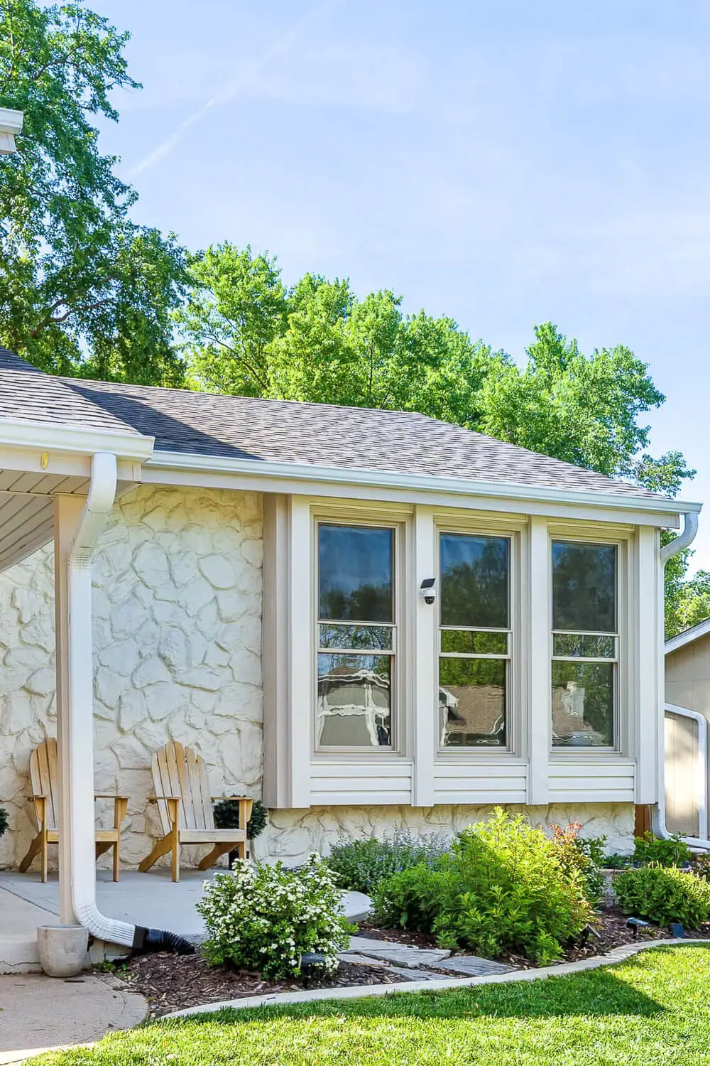 DIY home remodel after photo with updated siding, wood garage door, and new landscaping