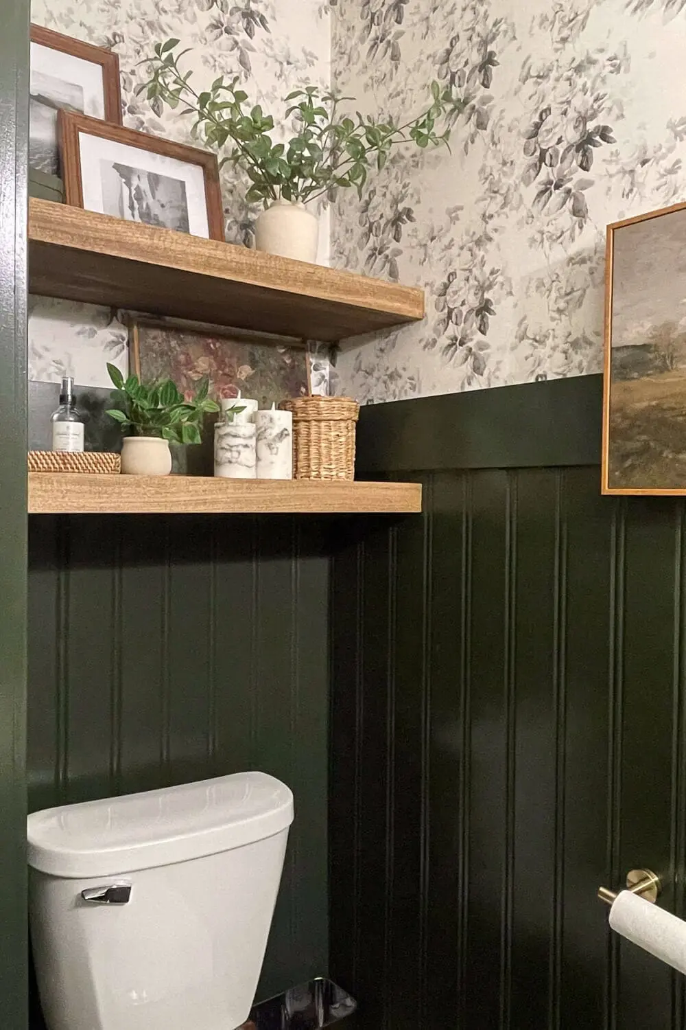 powder room with dark green beadboard, floating wood shelves, and floral wallpaper