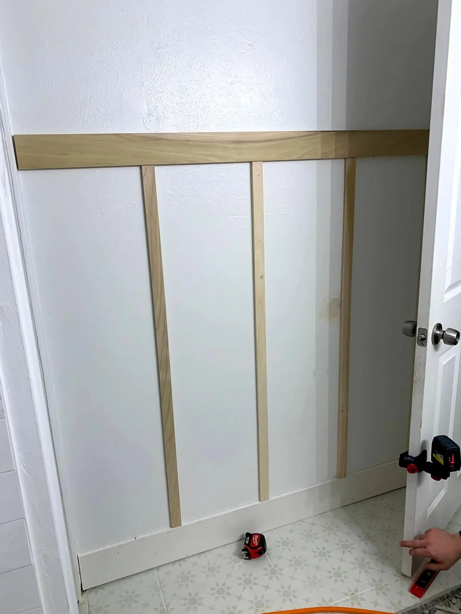 In-progress wall showing the top rail installed and battens laid out.