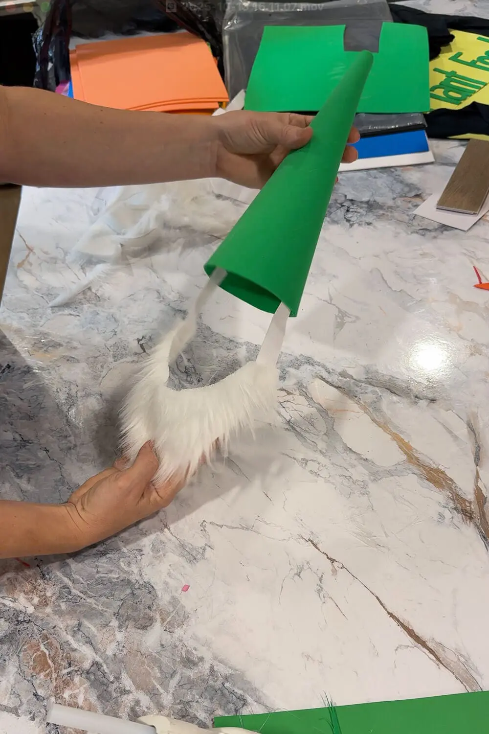 Finished DIY gnome costume hat with attached white faux fur beard and elastic band, ready for a child to wear.