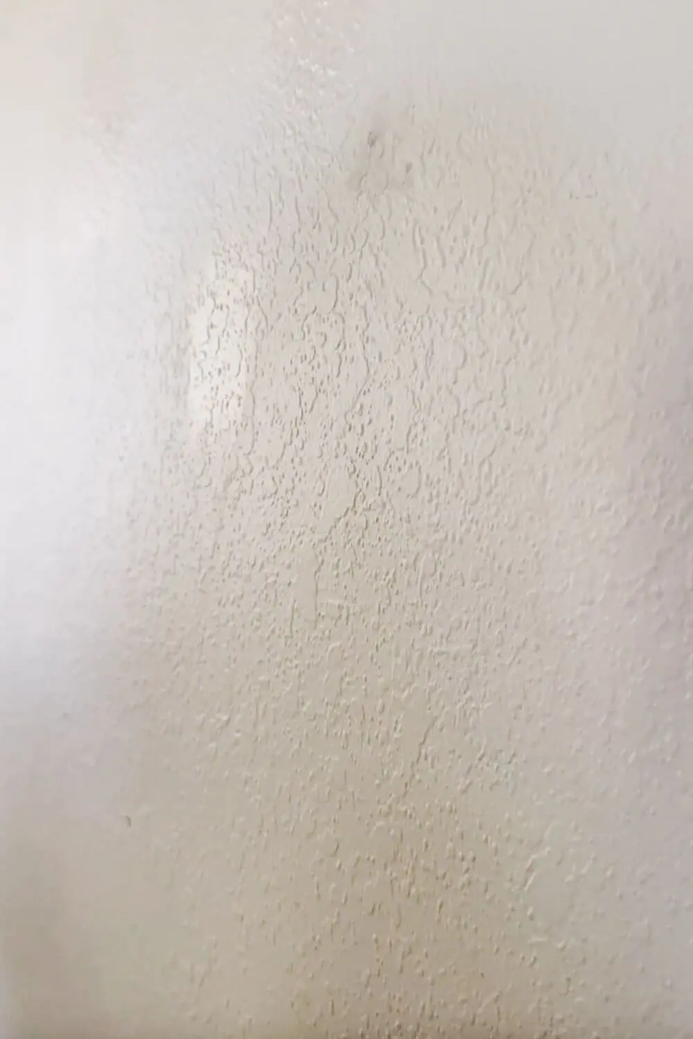 How to skim coat a wall: close-up of heavy orange peel texture before skim coating
