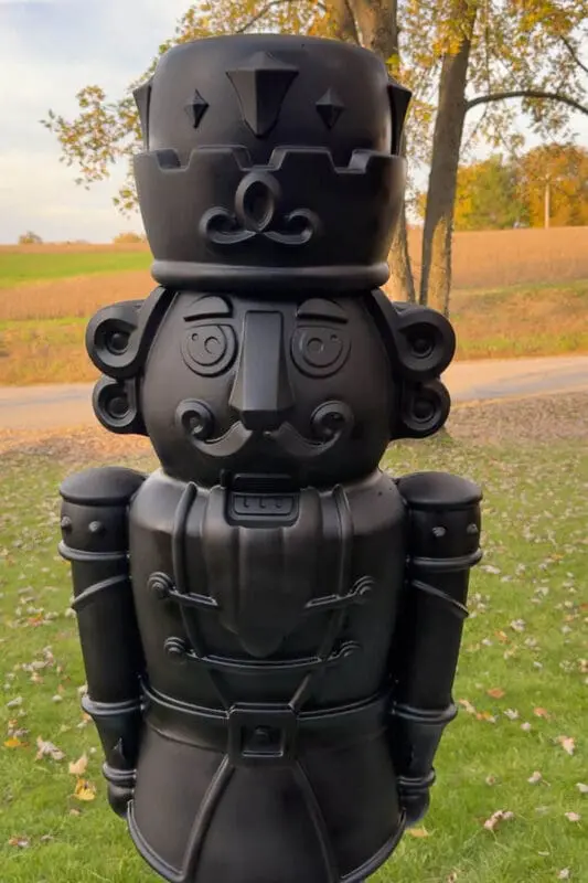 Close up of a black-DIY oversized Christmas decor standing in the yard.
